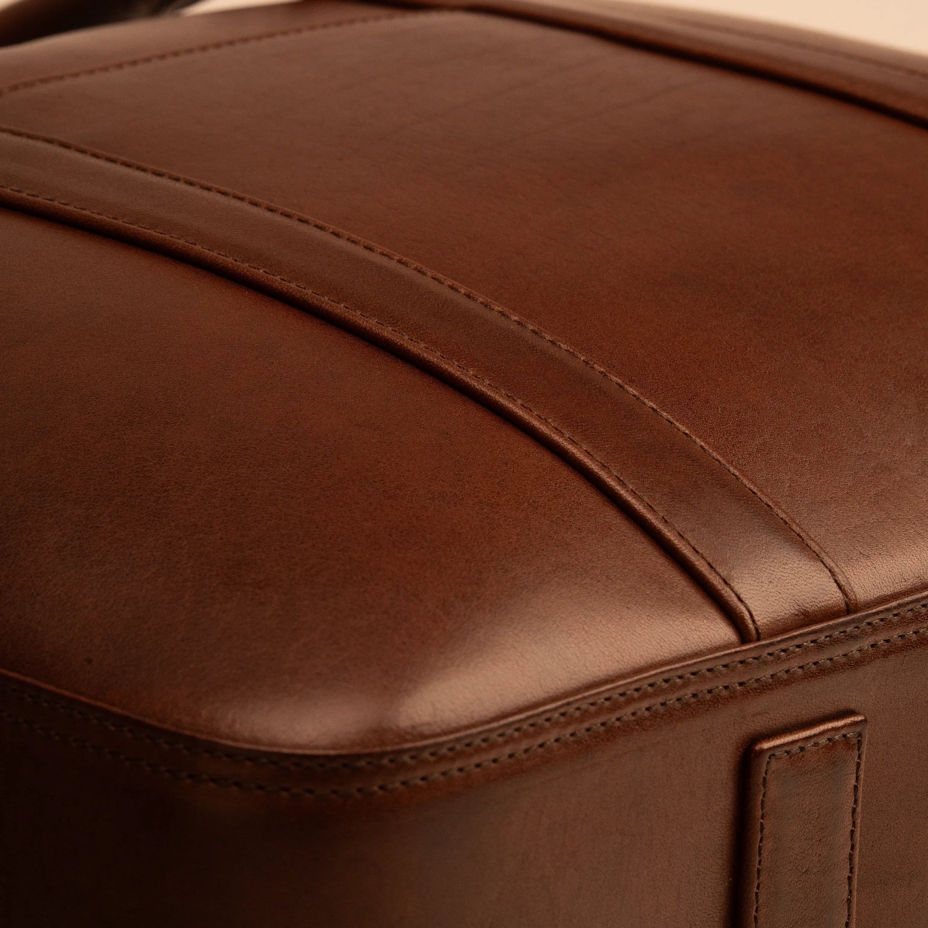Detail of the Lunburg Opus Briefcase in Deep Mahogany showing the precision panel seam and folded edge construction in vegetable-tanned Perpetual Leather (from Tempesti), precision executed to 0.1 mm tolerance.