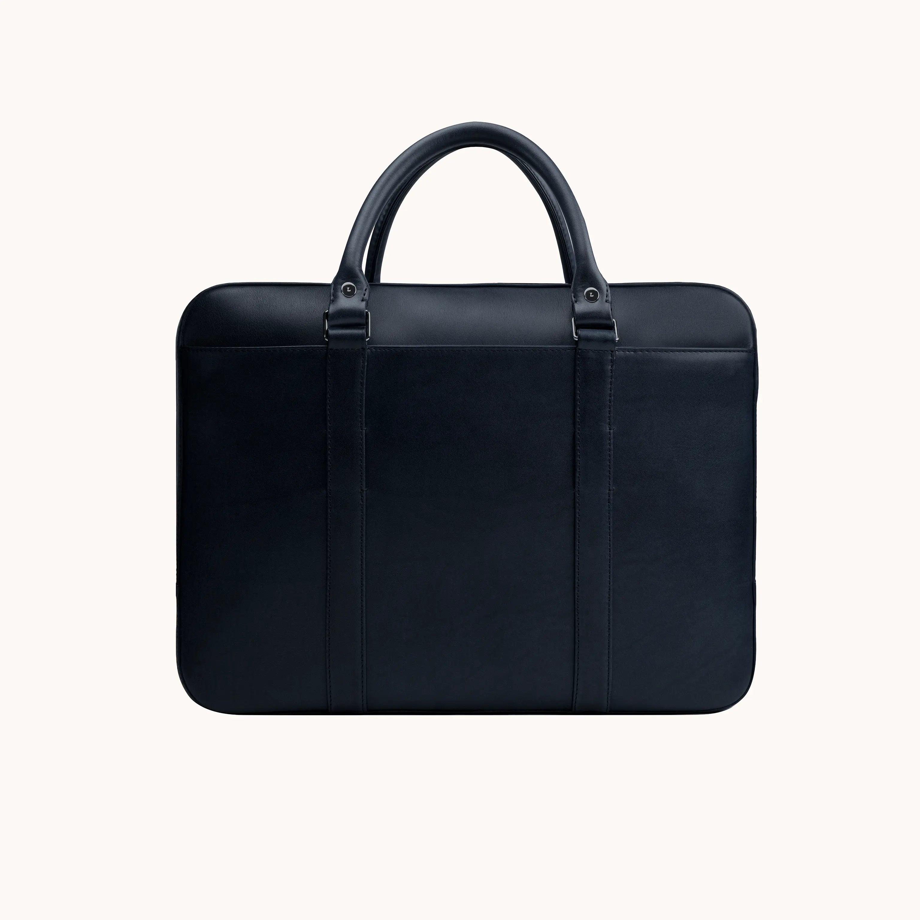 Lunburg Opus Briefcase in Nocturnal Sapphire vegetable-tanned Perpetual Leather (from Tempesti), back view showing clean panel construction, folded leather handles, and 316L stainless steel studs.