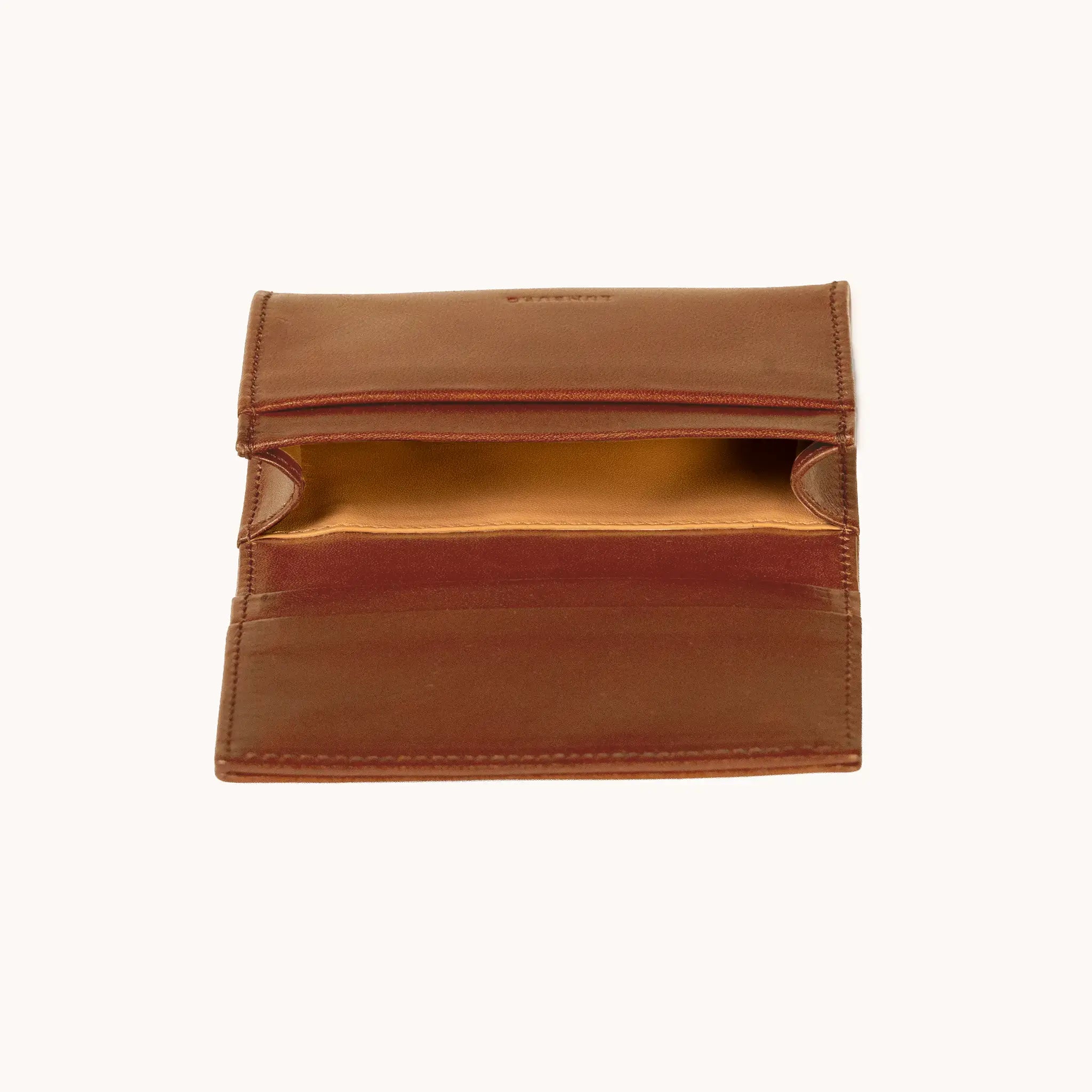 Lunburg Signet Business Card Wallet in Heritage Amber, interior profile view with flap lifted to reveal the goat leather lining of the central compartment and the card slot architecture, in vegetable-tanned Perpetual Leather (from Tempesti) with folded edge construction.