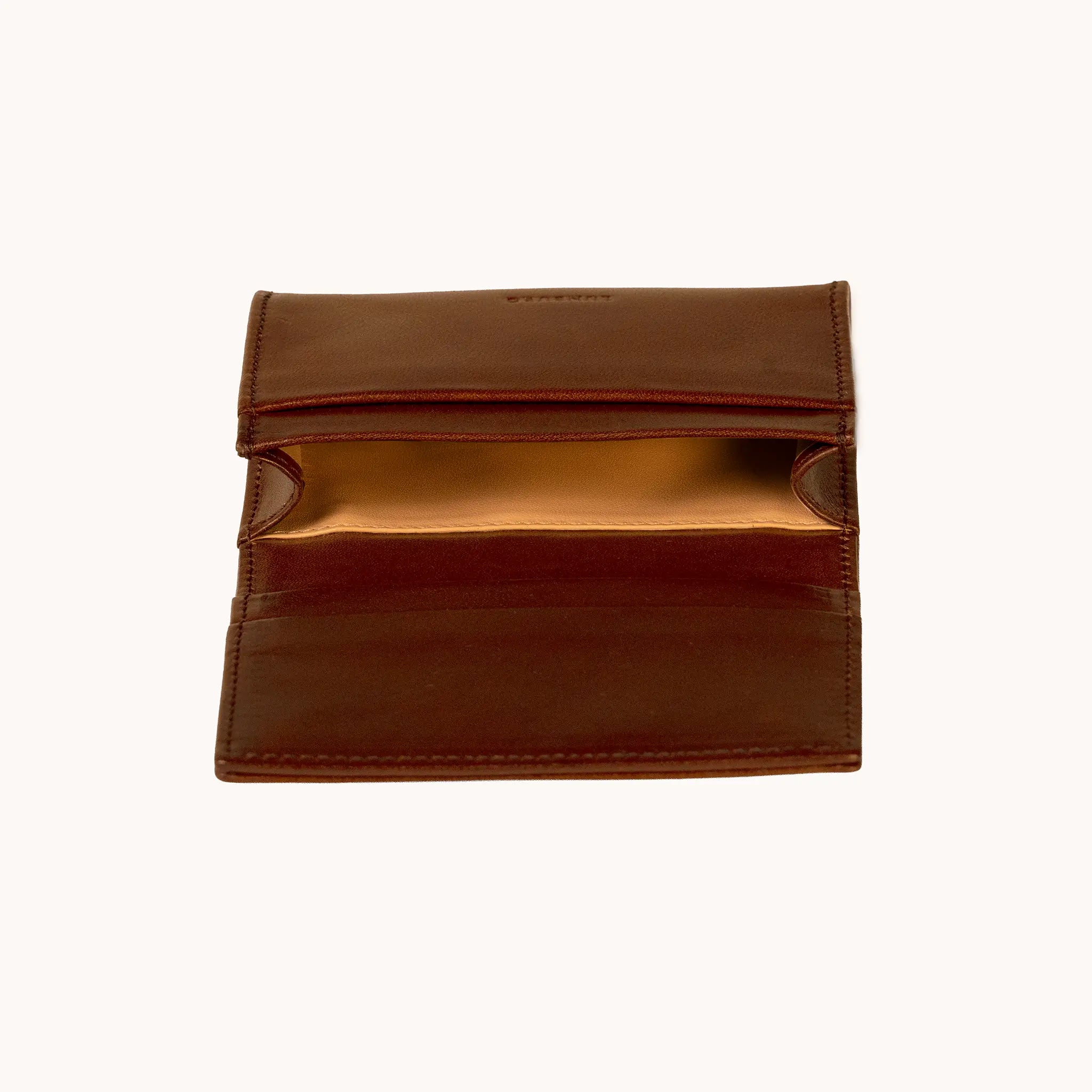 Lunburg Signet Business Card Wallet in Deep Mahogany, interior profile view with flap lifted to reveal the goat leather lining of the central compartment and the card slot architecture, in vegetable-tanned Perpetual Leather (from Tempesti) with folded edge construction.