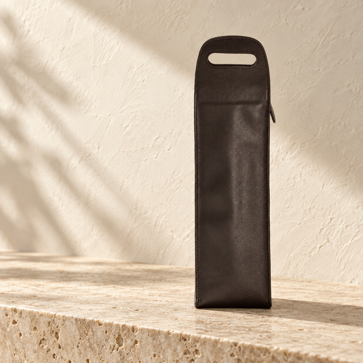 Illustrative cutout-handle bottle carrier, view 2: narrow side view shows upright body, rounded top handle cutout and vertical edge seam.