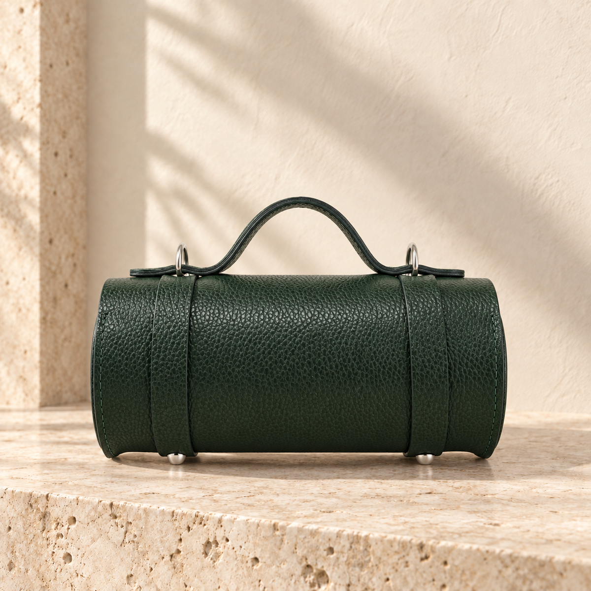 Alternate view of the illustrative cylindrical handbag showing the curved body, end panel and layered edge profiles.