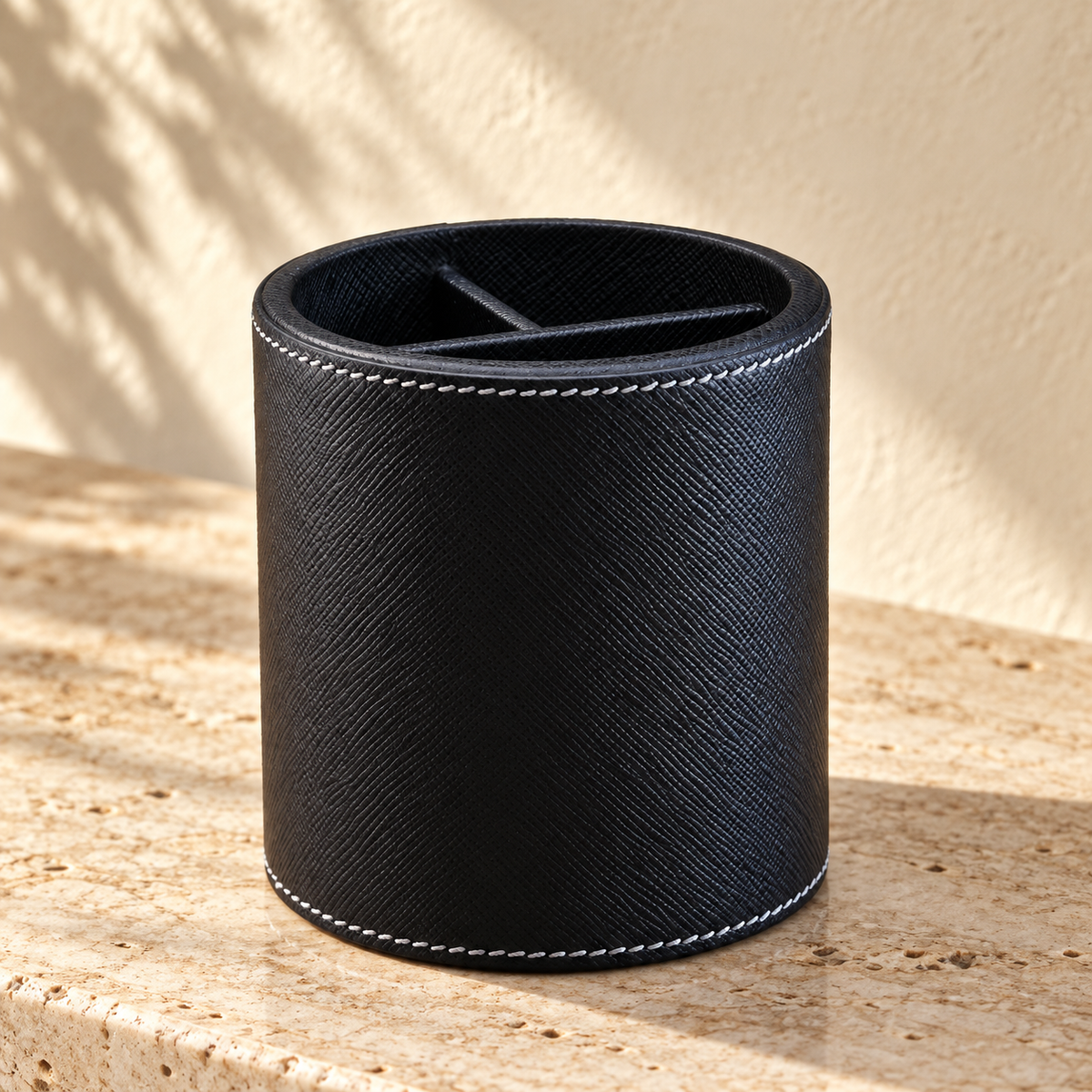 Illustrative divided round pen cup, view 1: cylindrical dark textured pen cup with pale stitch rows around top and bottom and visible inner dividers.
