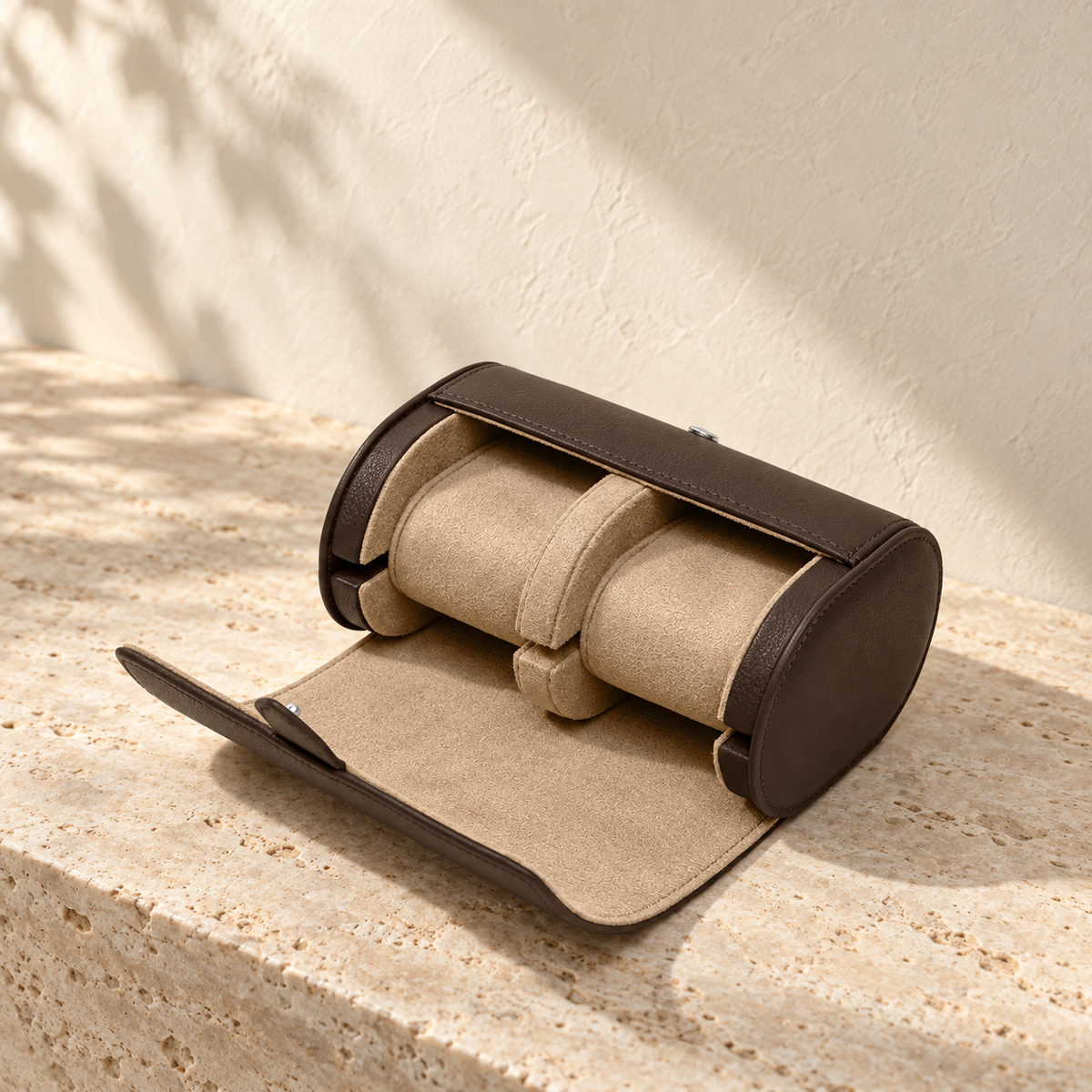 Illustrative divided two-cushion watch roll, view 2: open case shows two pale cylindrical cushions separated by a central divider, with the flap laid forward.