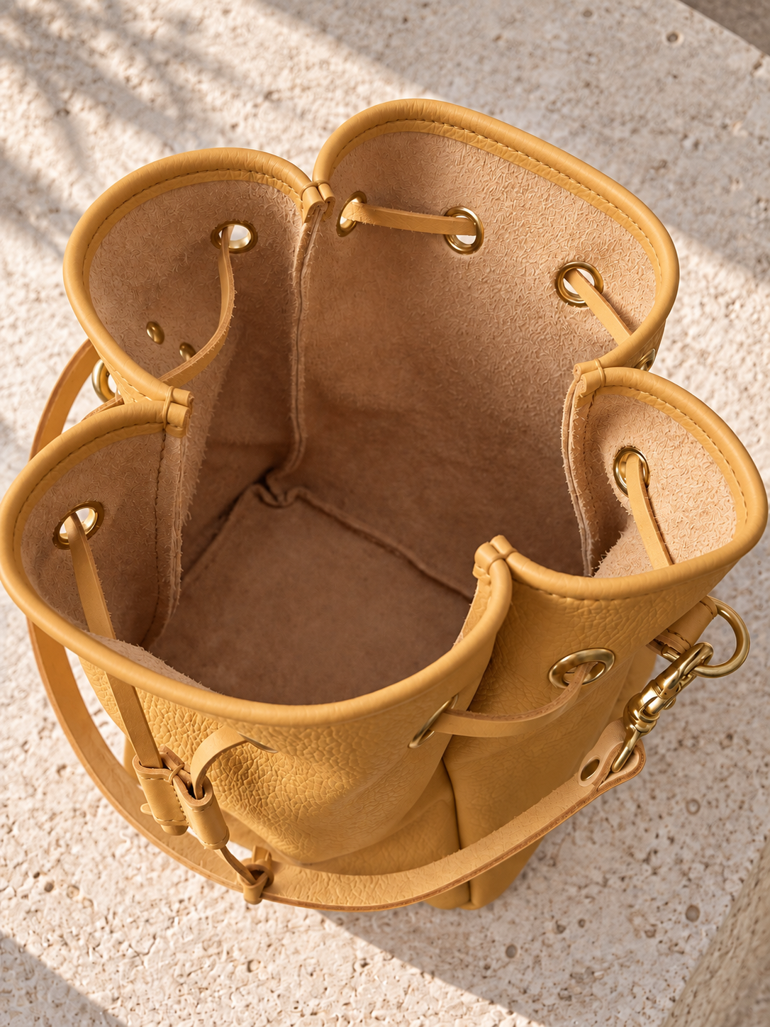 Open view of the illustrative bucket bag showing a suede-like inner surface, vertical seam allowances and joined base perimeter.
