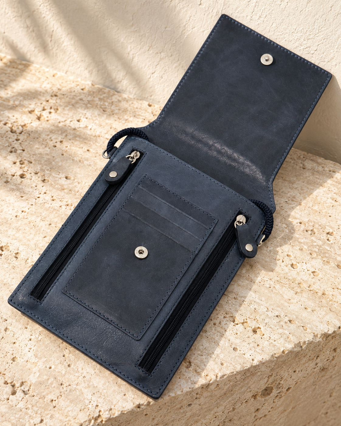 Open illustrative travel document pouch with a snap closure, two vertical zip pockets and three tiered card-slot openings.