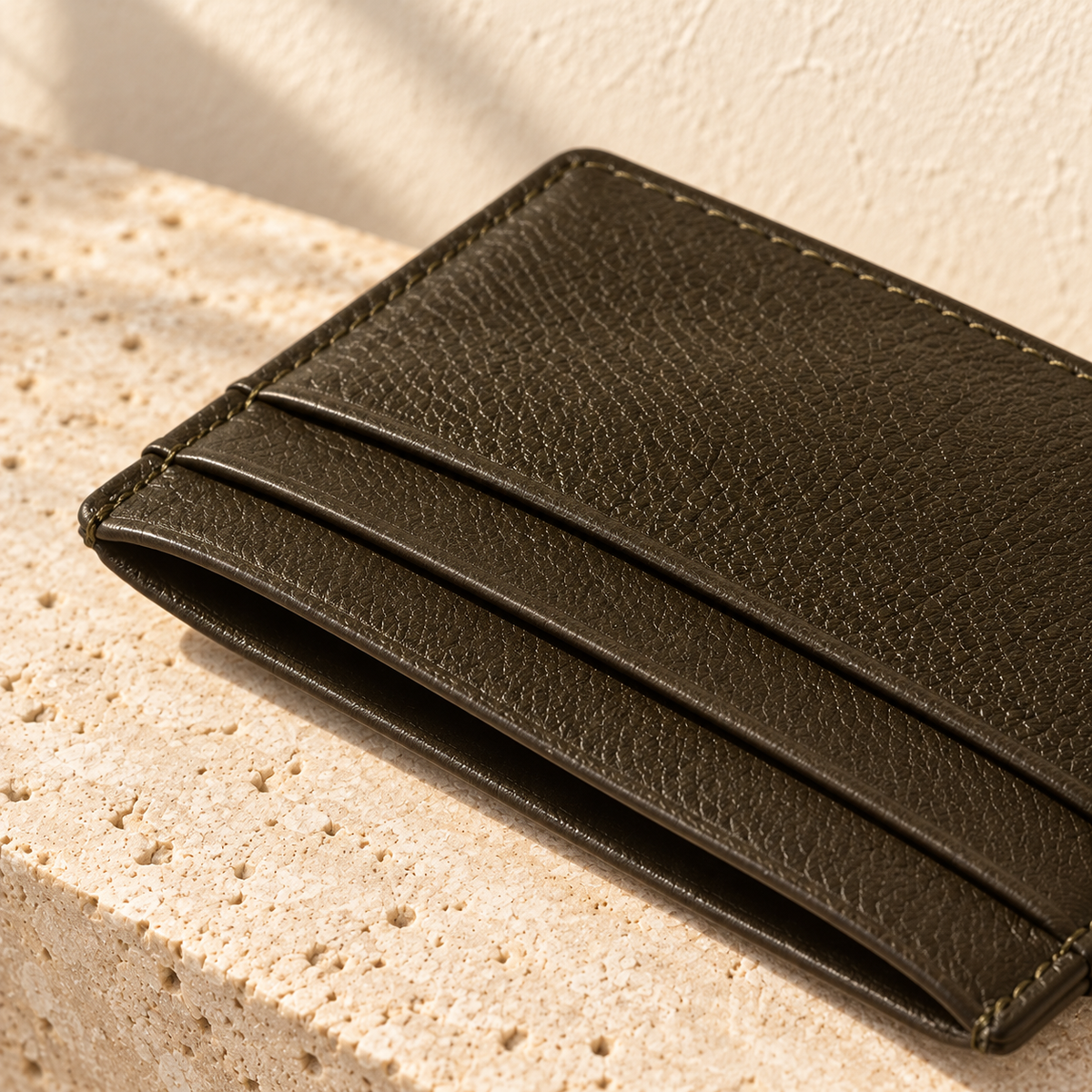 Illustrative flat pocket cardholder — corner macro shows fine grain appearance, pocket-mouth edges, border stitching and a dark finished perimeter.