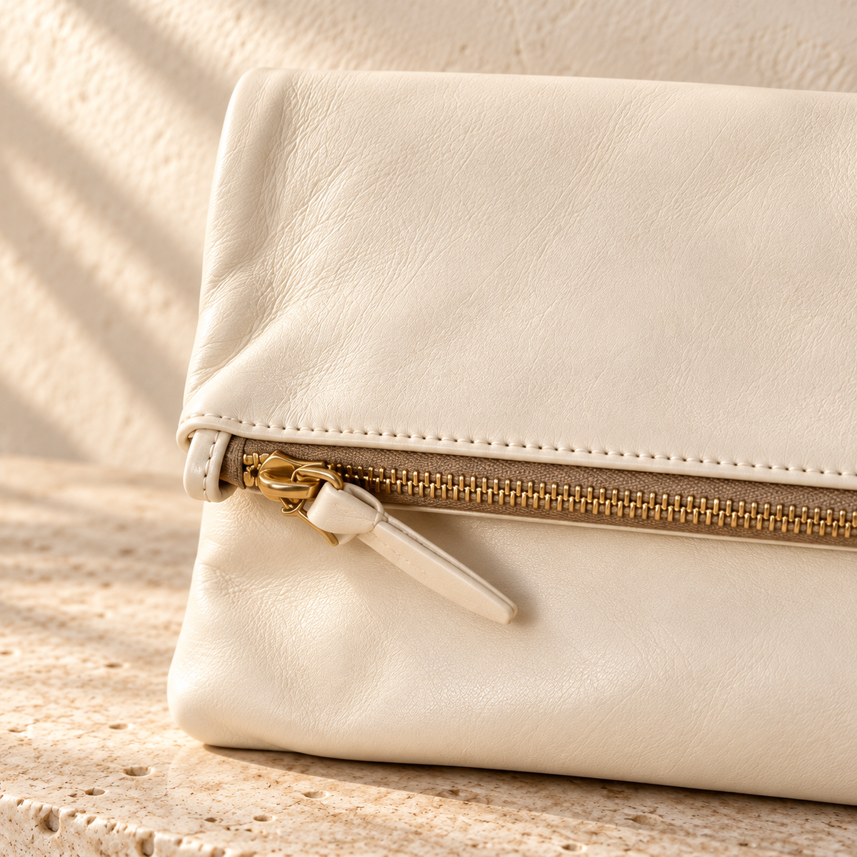 Detail der illustrativen Faltclutch mit Metallreißverschluss, lederartig wirkendem Zipper und sichtbarer Reißverschlussnaht.