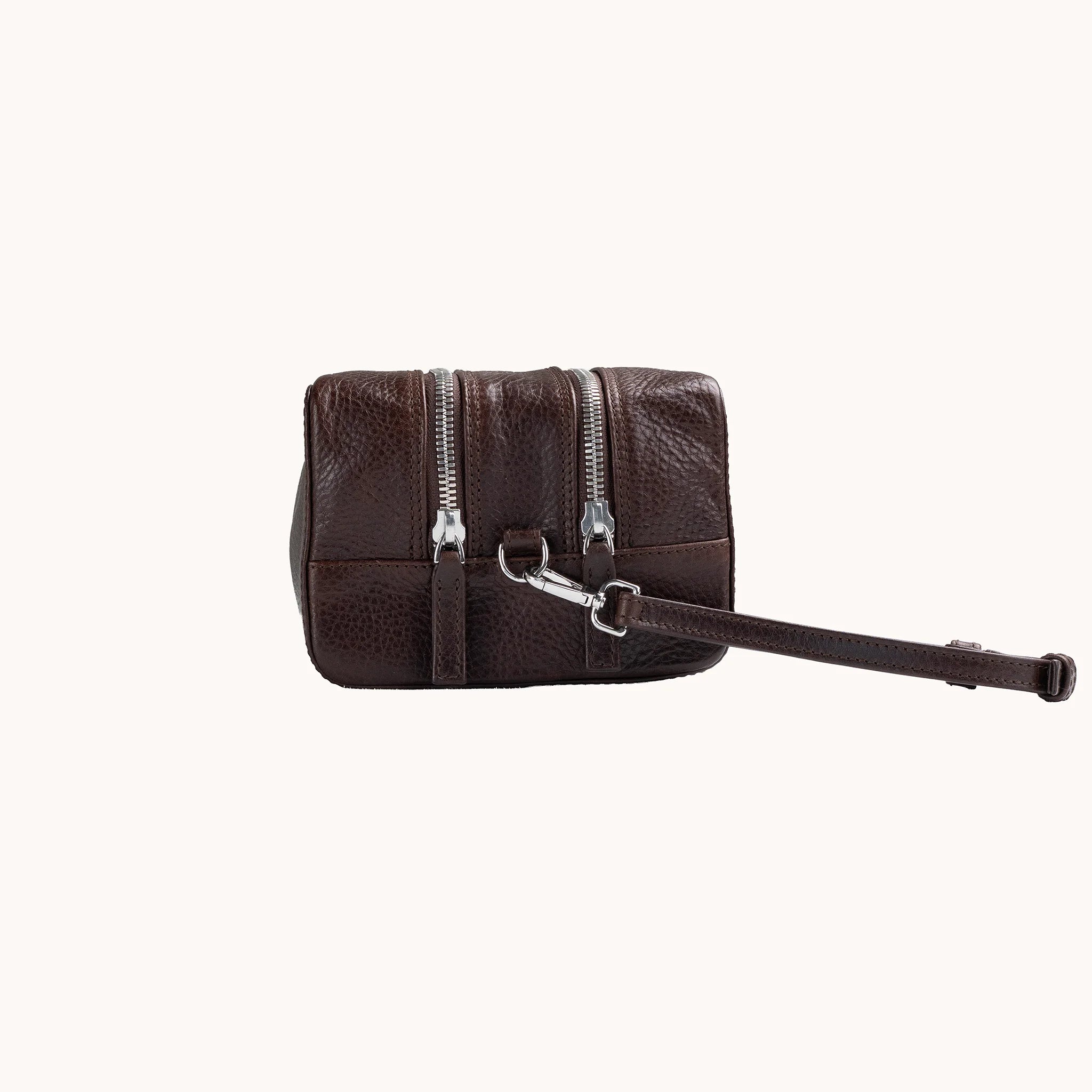 Lunburg Chamberlain Grand Toiletry Bag in tumbled Deep Mahogany leather, side profile with carrying handle visible.