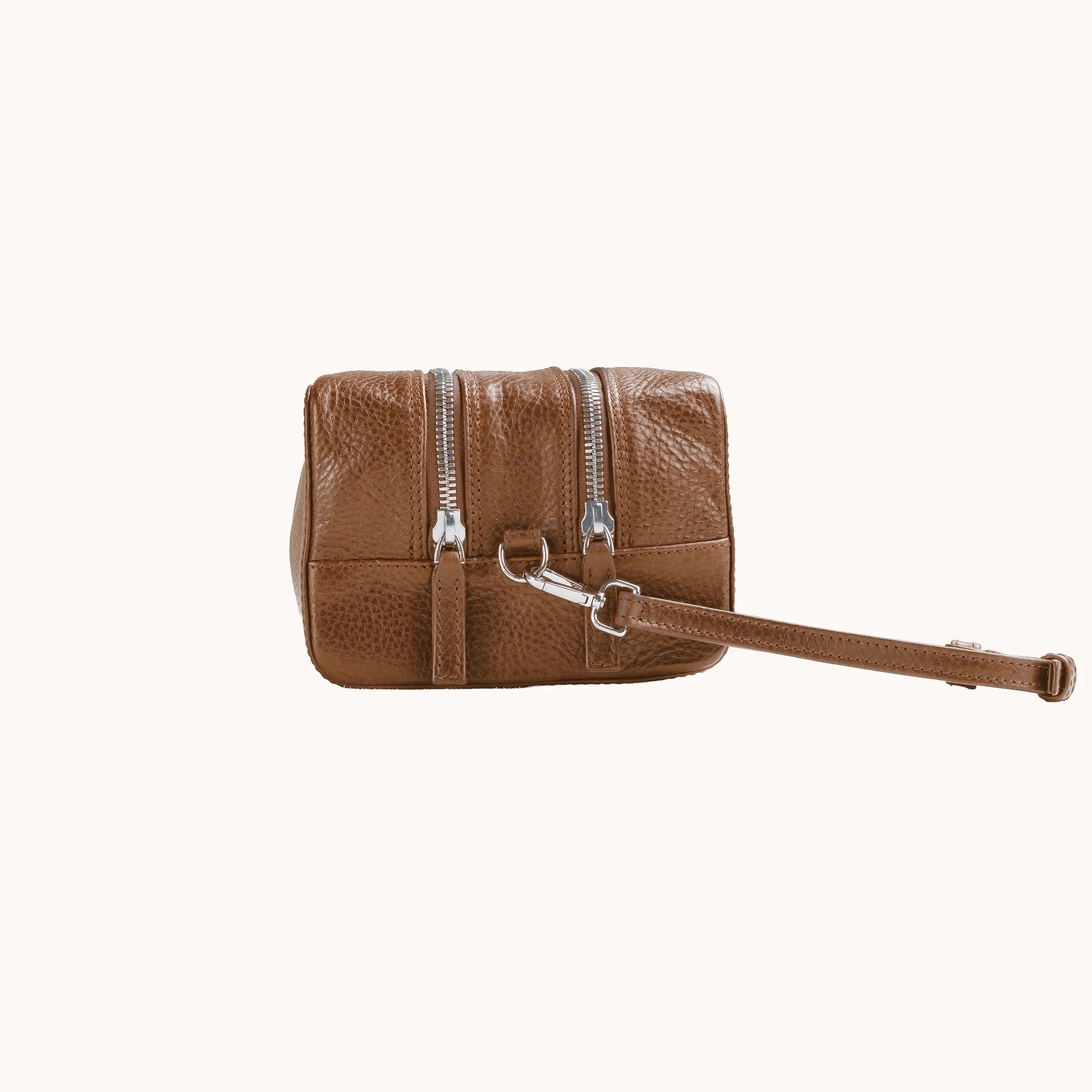 Lunburg Chamberlain Grand Toiletry Bag in tumbled Heritage Amber leather, side profile with carrying handle visible.