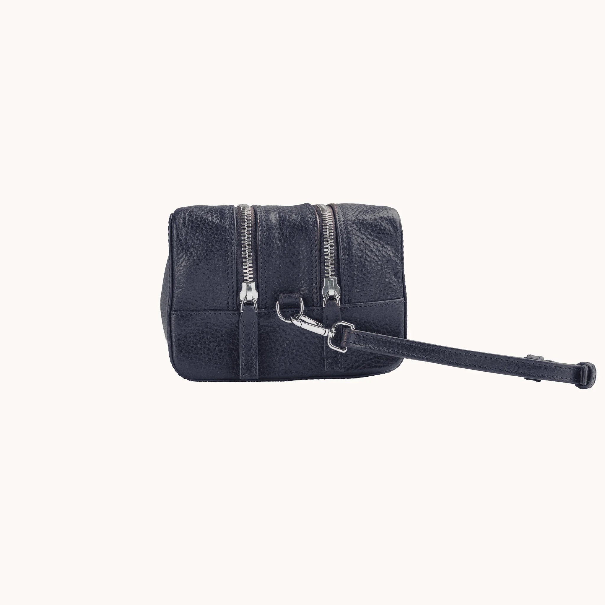 Lunburg Chamberlain Grand Toiletry Bag in tumbled Nocturnal Sapphire leather, side profile with carrying handle visible.