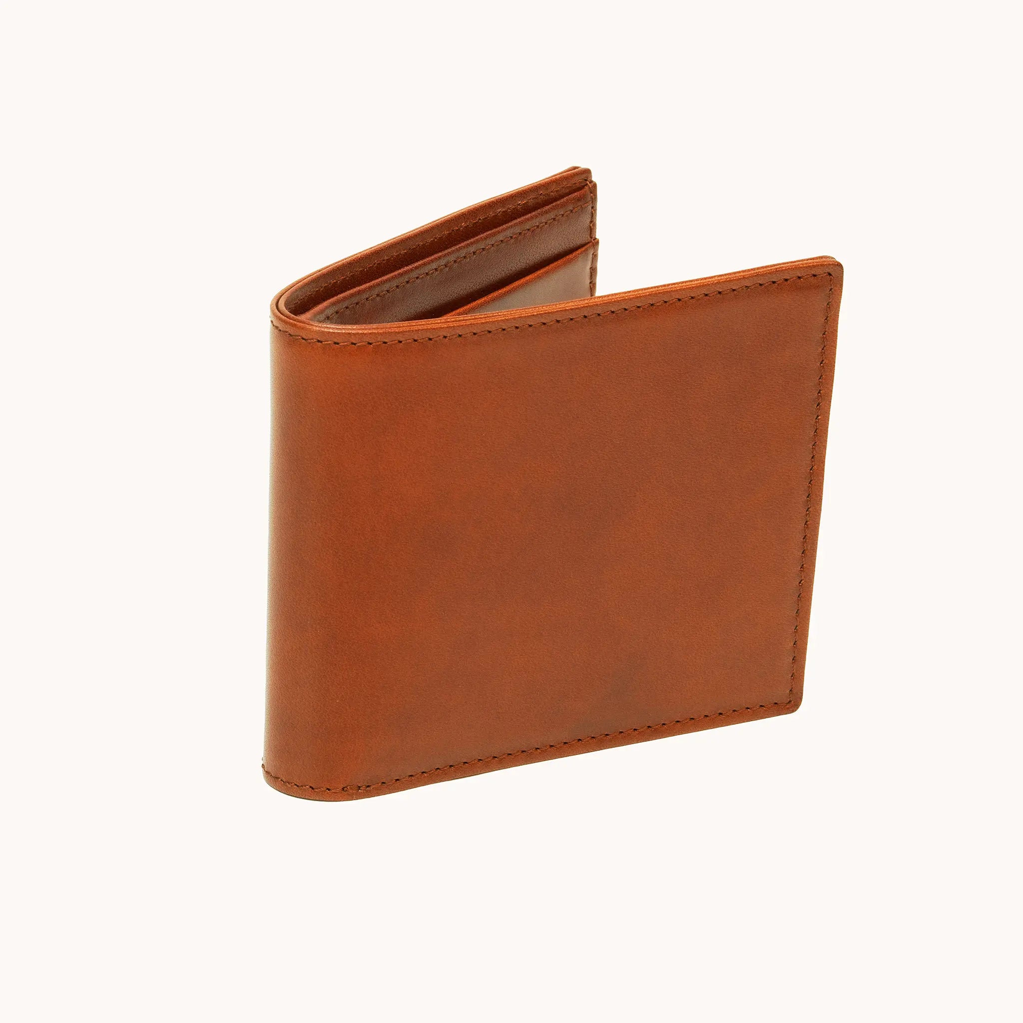 Lunburg Horizontal Signet Bifold Wallet in Heritage Amber at a three-quarter angle, slightly open, showing the slim profile, folded edge construction, and edge stitching in vegetable-tanned Perpetual Leather.