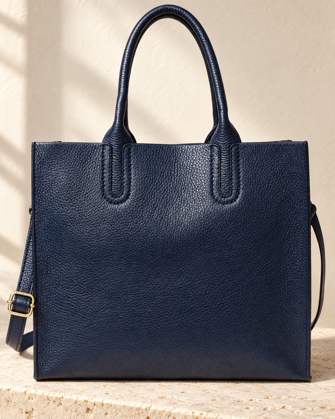 Illustrative upright tote with separate rolled handles continuing into long stitched mounts.
