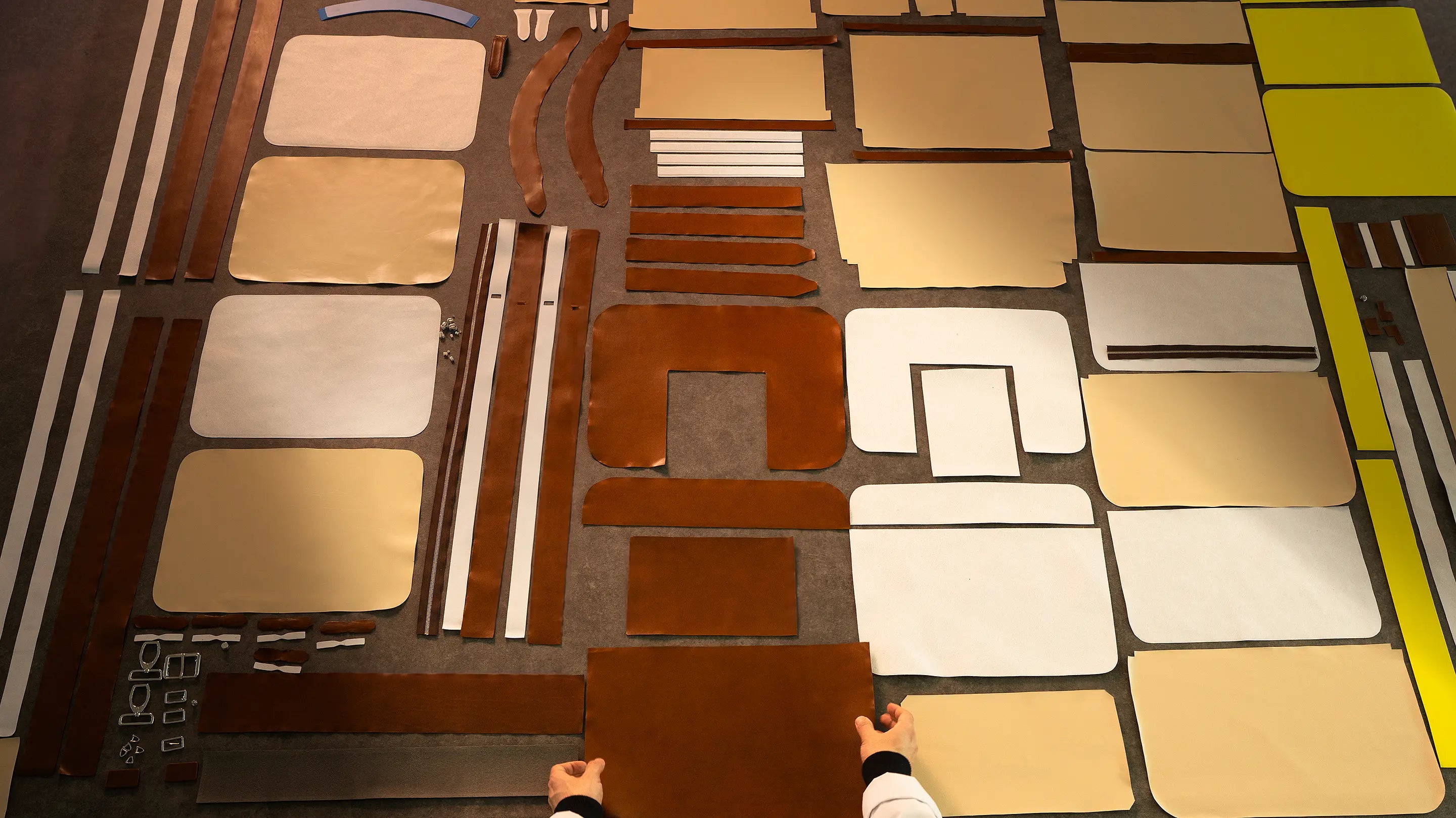 140 hand-cut panels of the Lunburg Opus Briefcase laid out in precise arrangement, exterior Perpetual Leather (from Tempesti) and interior goat leather components with 316L stainless steel hardware, Poron XRD padding, Lorenzi Lyliane reinforcement, the full anatomy of a grand complication in leathercraft.