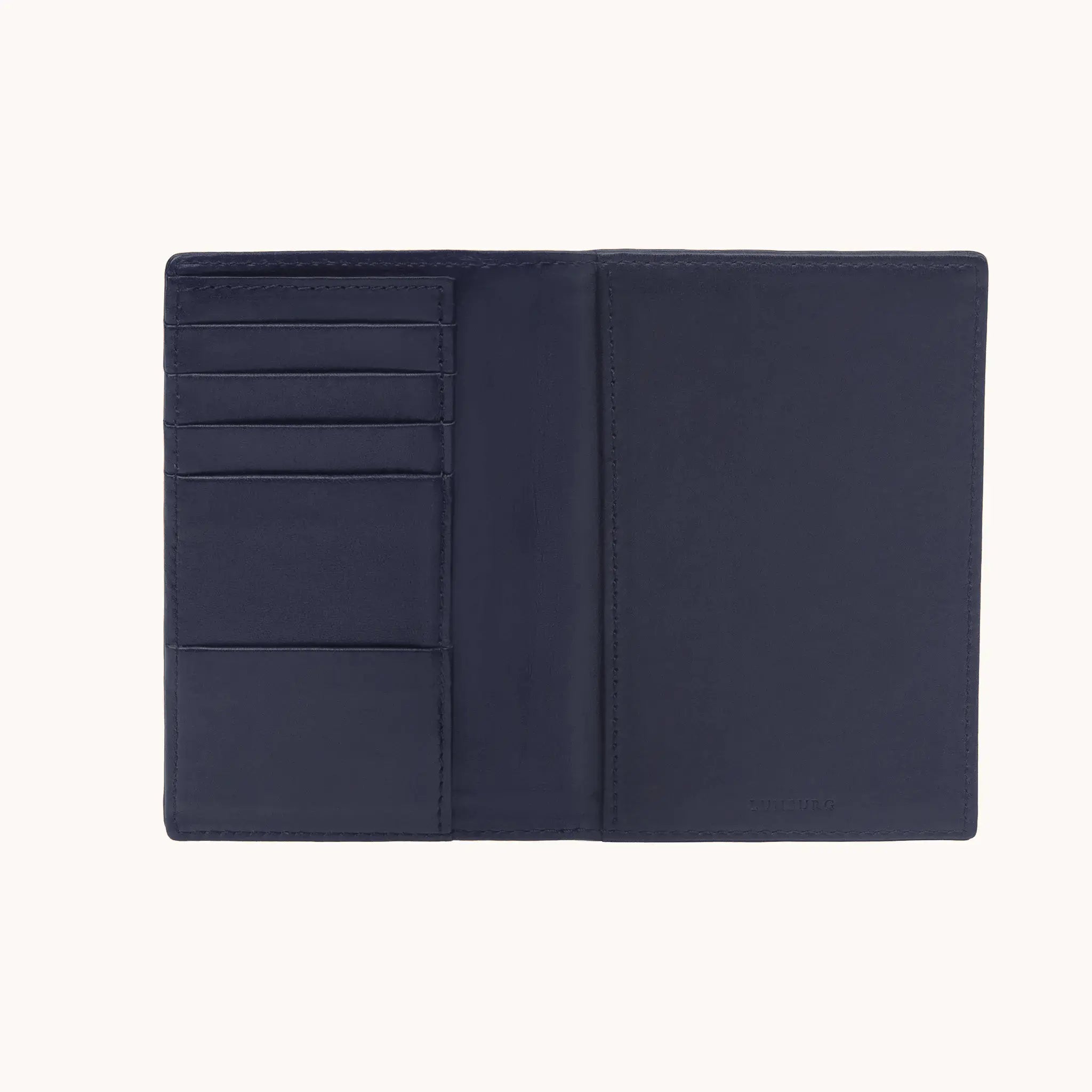 Lunburg Signet Passport Folio in Nocturnal Sapphire, fully open interior view showing card slots and an open pocket on the left panel, a full-height passport sleeve on the right panel, and the heat-embossed Lunburg mark on the lower right, in vegetable-tanned Perpetual Leather (from Tempesti) with folded edge construction throughout.