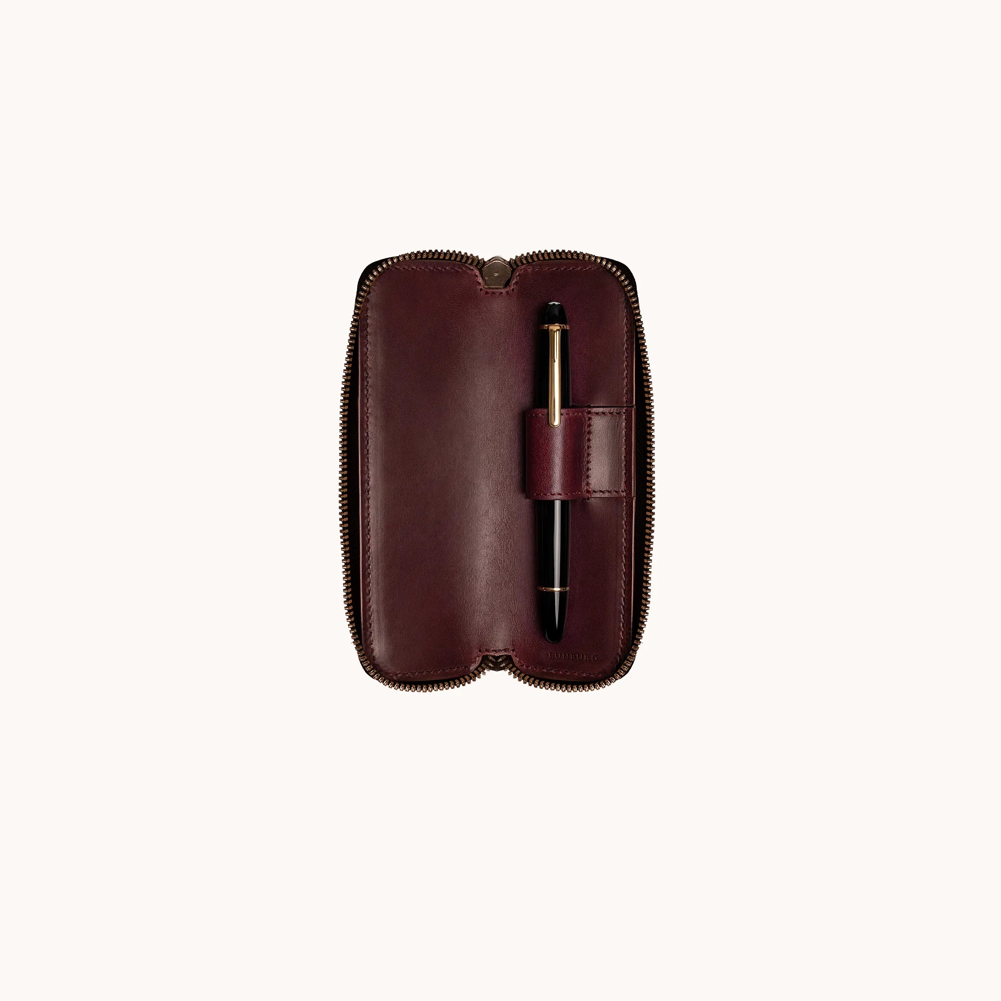Lunburg Single Pen Case Curator in Deep Mahogany, interior view with Montblanc Meisterstück seated in the single leather pen loop, goat leather lining shown across the full interior, heat-embossed Lunburg mark at lower edge, YKK Excella zipper framing the perimeter.