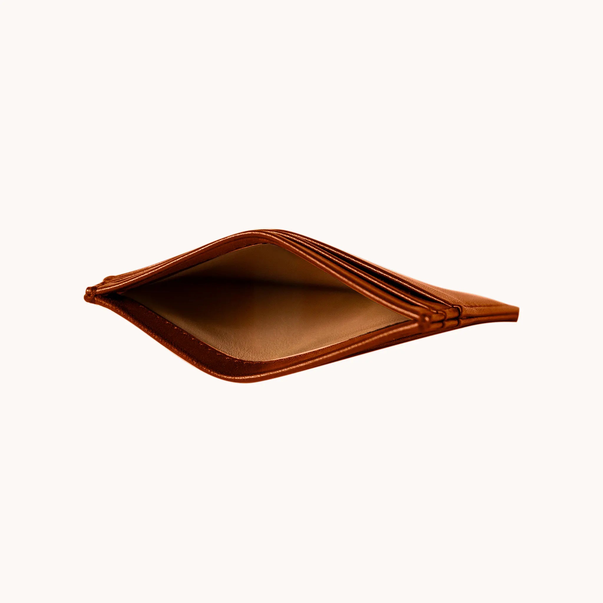 Lunburg Signet Card Holder in Heritage Amber opened at eye level, revealing the interior goat lining cavity, card slot layers, and folded edge construction in vegetable-tanned Perpetual Leather.