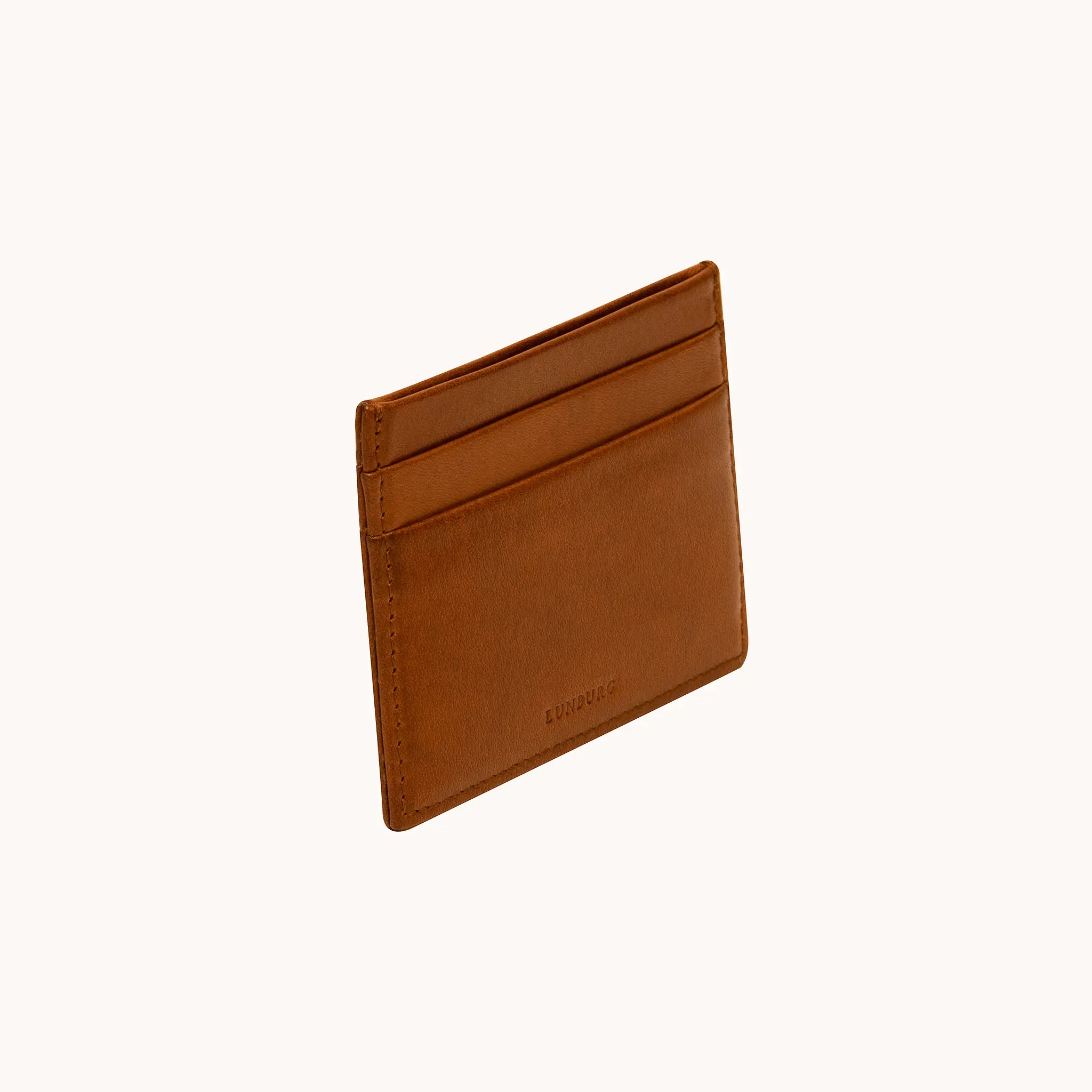 Lunburg Signet Card Holder in Heritage Amber at a three-quarter angle, showing card slots, heat-embossed Lunburg mark, and folded edge construction in vegetable-tanned Perpetual Leather.