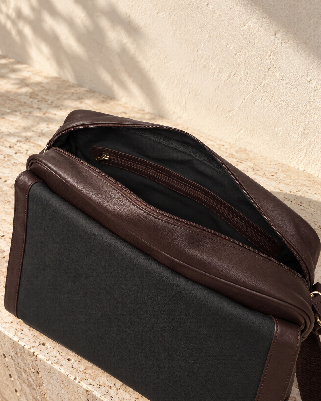 Open illustrative messenger showing dark lining and a long trimmed internal zip pocket.