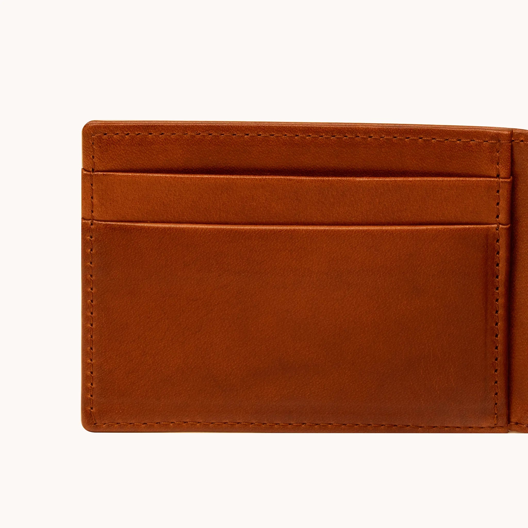 Close-up of card slots on the interior of the Lunburg Small Horizontal Signet Wallet in Heritage Amber, showing folded edge construction, saddle stitching, and leather grain in vegetable-tanned Perpetual Leather.