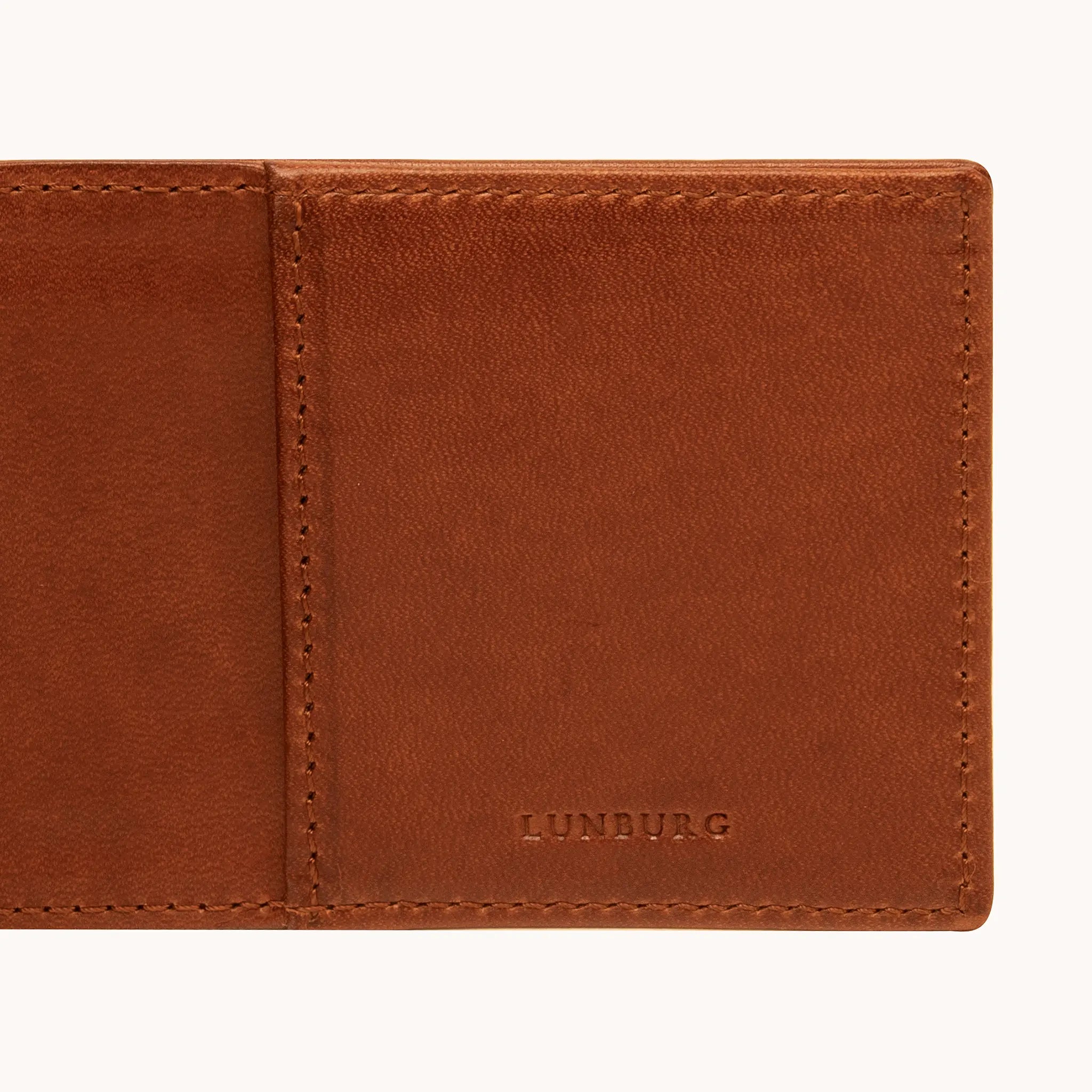 Close-up of the heat-embossed Lunburg mark on the interior of the Small Horizontal Signet Wallet in Heritage Amber, with folded edge construction and saddle stitching visible, in vegetable-tanned Perpetual Leather.