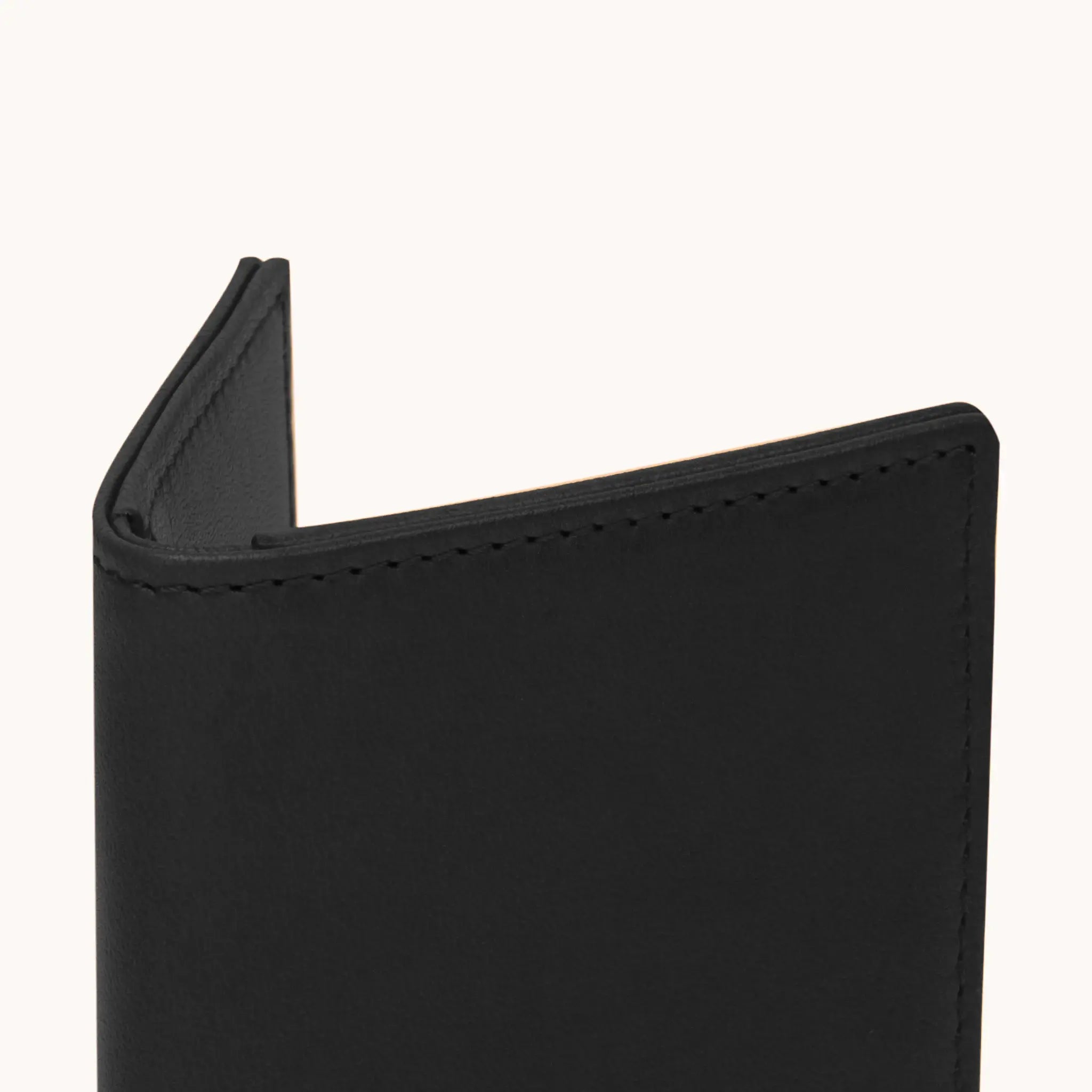 Lunburg Signet Small Vertical in Burnt Timber, close-up detail of the spine and upper card slot edges showing the folded edge construction of Rempliage where no raw edges are visible, in vegetable-tanned Perpetual Leather (from Tempesti).