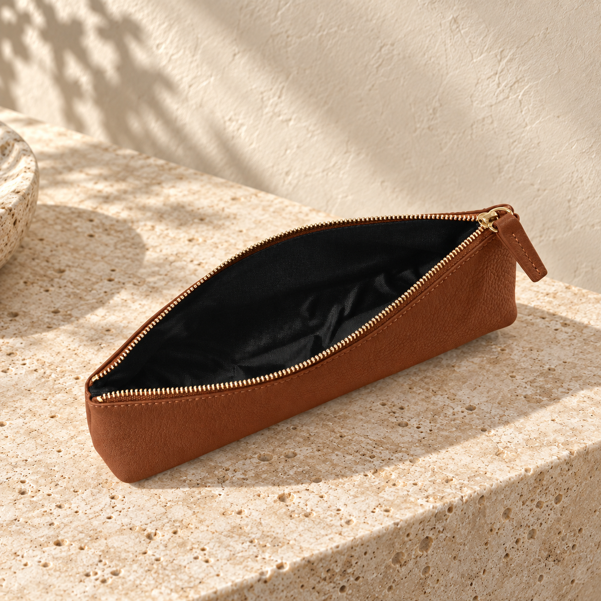 Illustrative standing zip pencil pouch — open pouch showing one visible cavity with a black fabric-like interior.