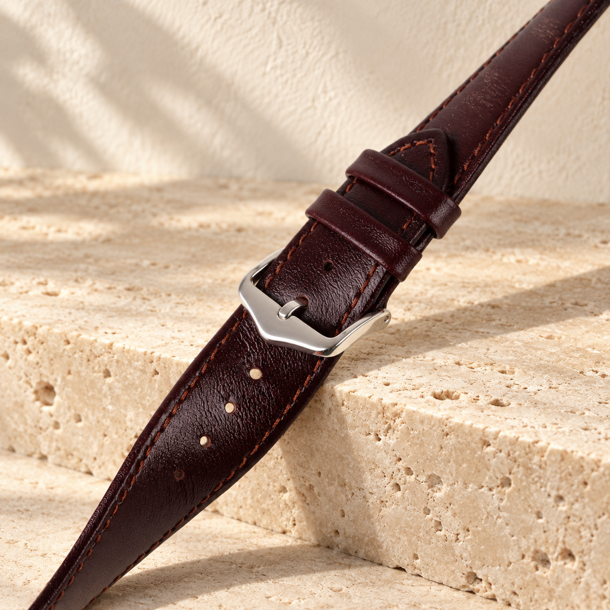 Illustrative tapered tang-buckle watch strap, view 3: fastened tang buckle, two keeper loops and visible adjustment holes shown close up.