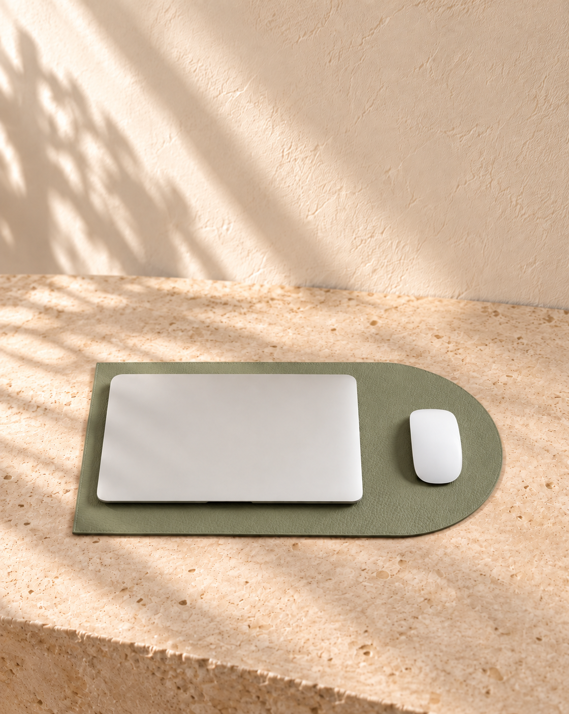 Illustrative unfolding work-surface sleeve — extended flat form acts as a work surface, with laptop over rectangular area and mouse over rounded extension.