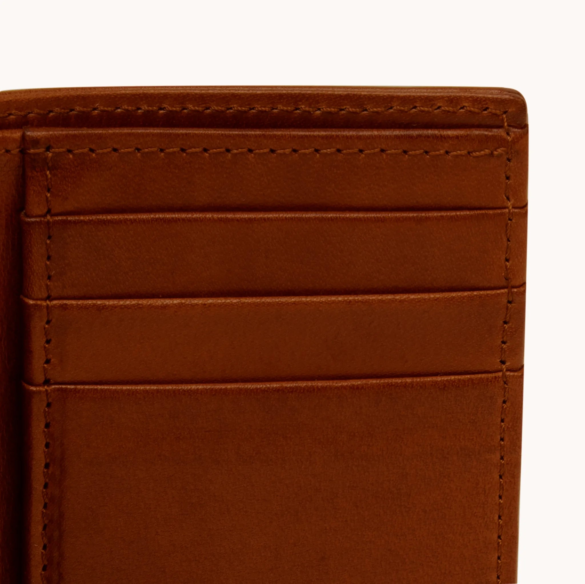 Lunburg Signet Vertical Bifold in Deep Mahogany, close-up detail of the interior card slot layering showing the folded edge construction of Rempliage on each pocket edge, in vegetable-tanned Perpetual Leather (from Tempesti)