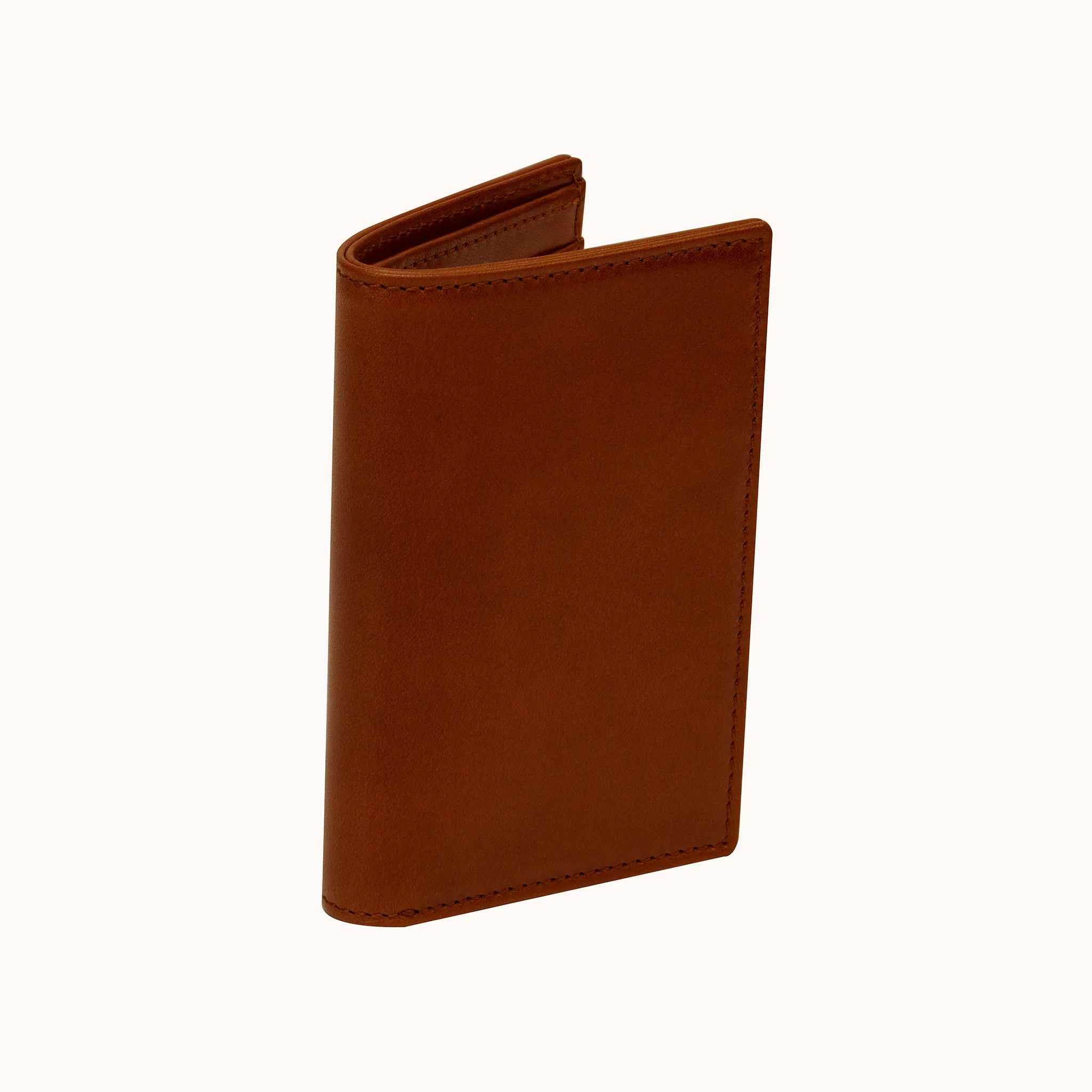Lunburg Signet Vertical Bifold in Deep Mahogany, three-quarter view slightly open showing the exterior grain, spine, and a glimpse of the interior, in vegetable-tanned Perpetual Leather (from Tempesti) with folded edge construction.