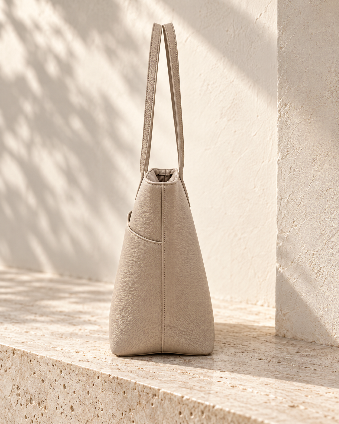 Side view of the illustrative work tote showing a full-depth panel, vertical join and exterior pocket edge.