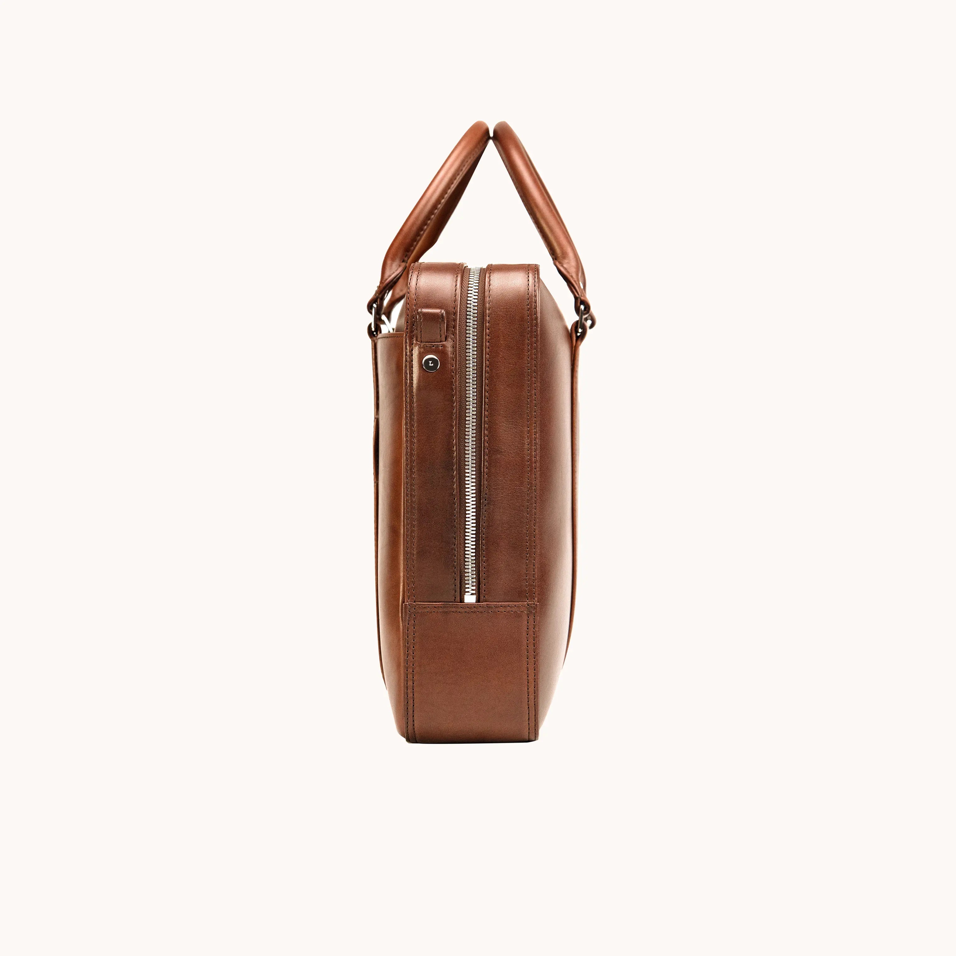 Lunburg Opus Briefcase in Deep Mahogany vegetable-tanned Perpetual Leather (from Tempesti), side view showing YKK Excella zipper, profile depth, folded leather handles, and exterior side pocket.