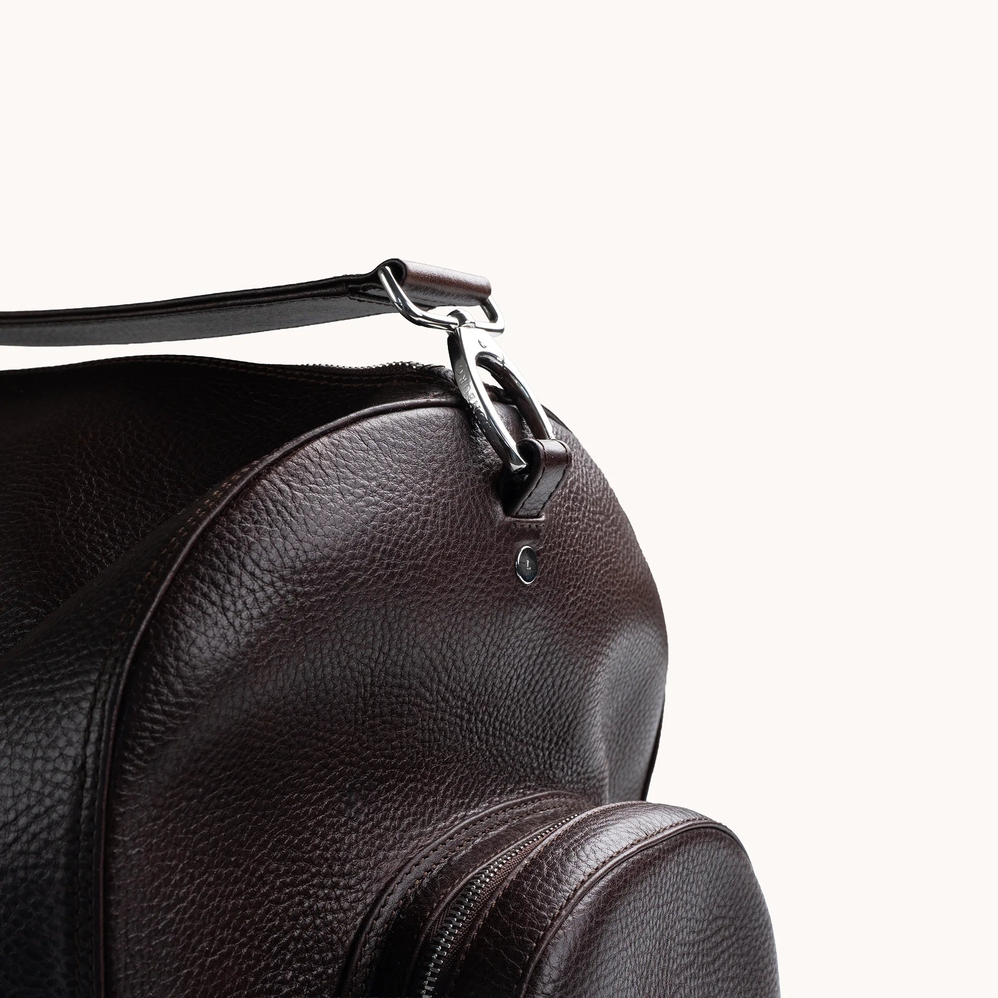 Estate Duffle Bag in Deep Mahogany, strap clasp detail with the L-branded stainless steel stud.