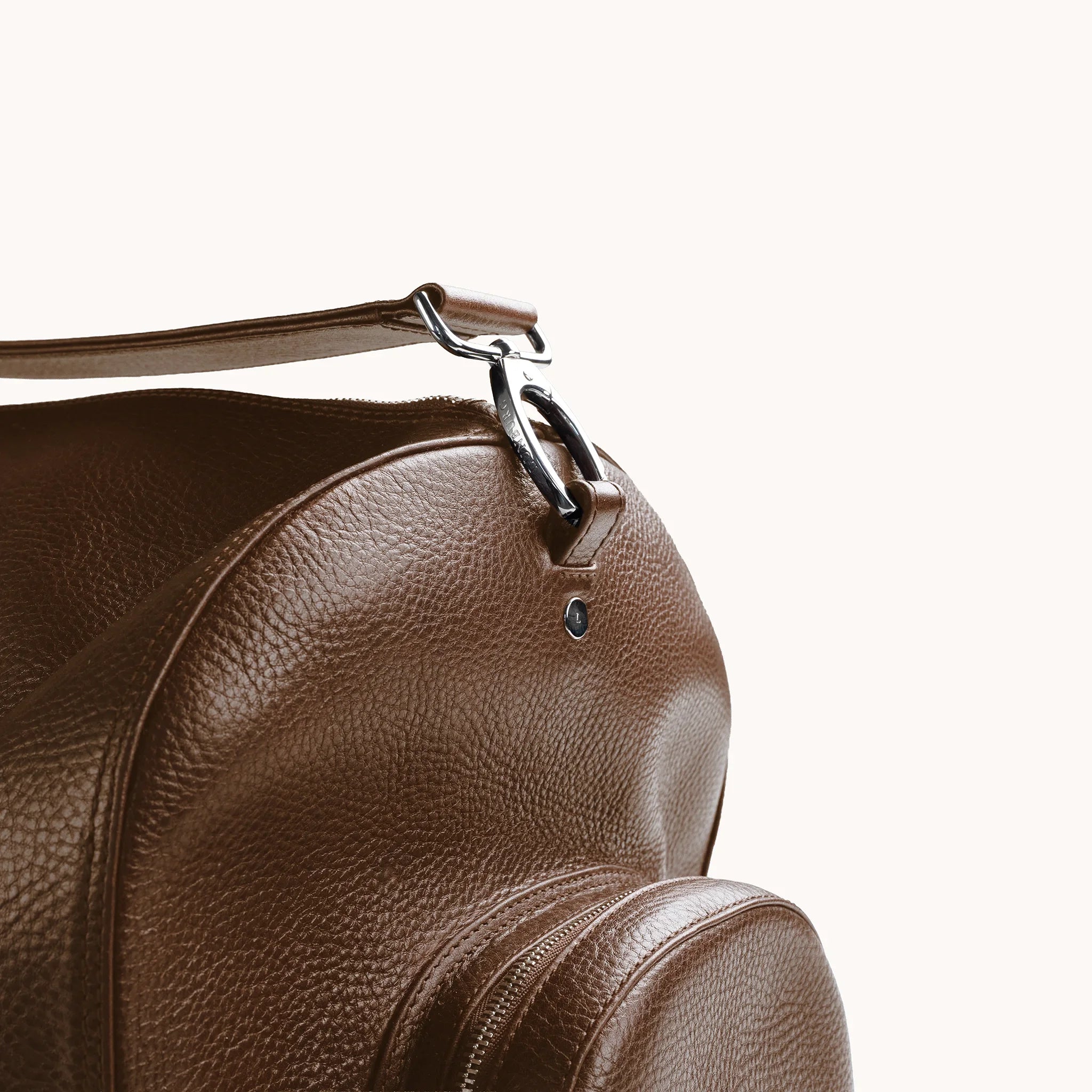 Estate Duffle Bag in Heritage Amber, strap clasp detail with the L-branded stainless steel stud.