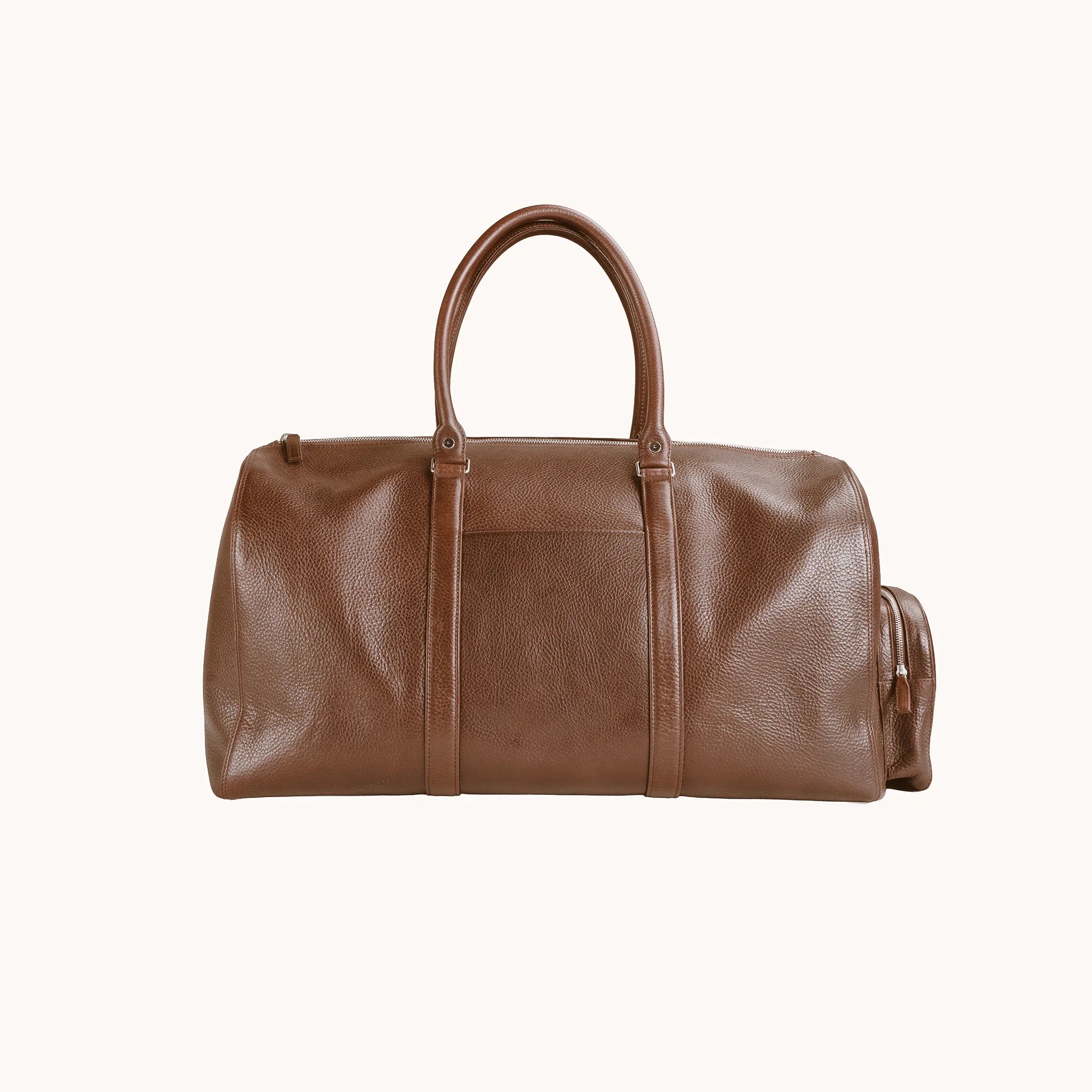 Lunburg Estate Duffle Bag in tumbled Heritage Amber leather, front view with twin top handles and exterior trim.