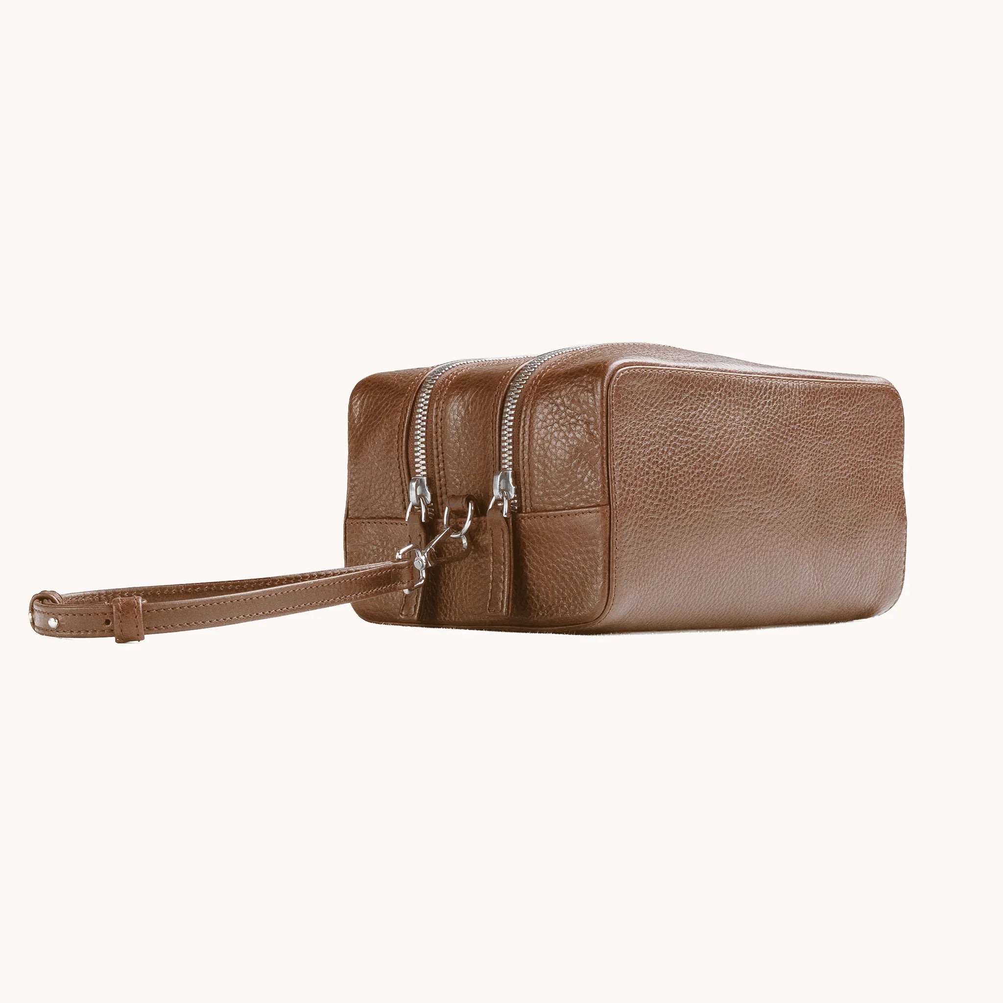 Lunburg Chamberlain Grand Toiletry Bag in tumbled Heritage Amber leather, three-quarter view showing depth and zip line.