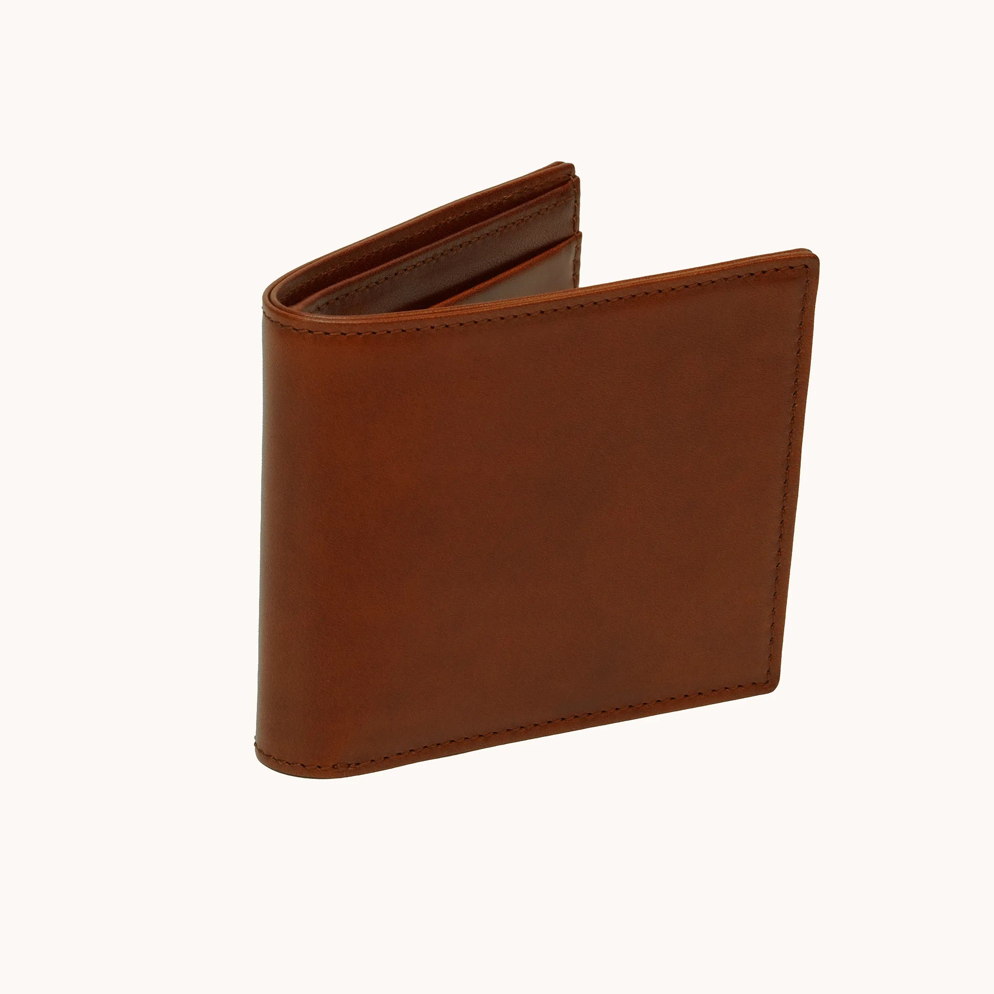 Lunburg Signet Horizontal Bifold in Deep Mahogany, three-quarter view slightly open showing the exterior grain, spine, and a glimpse of the goat leather lining interior, in vegetable-tanned Perpetual Leather (from Tempesti) with folded edge construction.