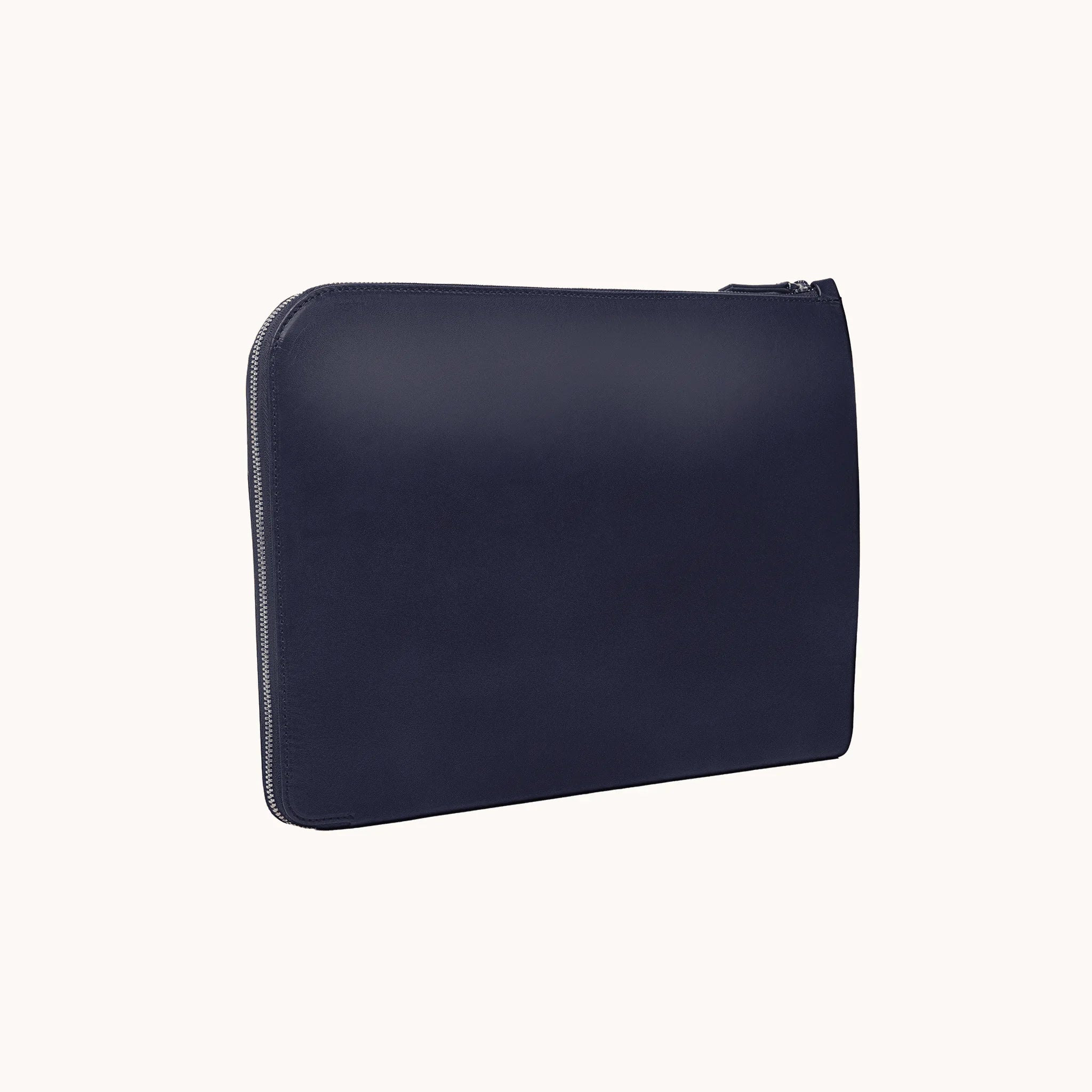 Lunburg Memoir Laptop Sleeve in Nocturnal Sapphire, three-quarter front view showing the clean face, top YKK Excella zipper, and slim profile, in vegetable-tanned Perpetual Leather (from Tempesti) with folded edge construction.
