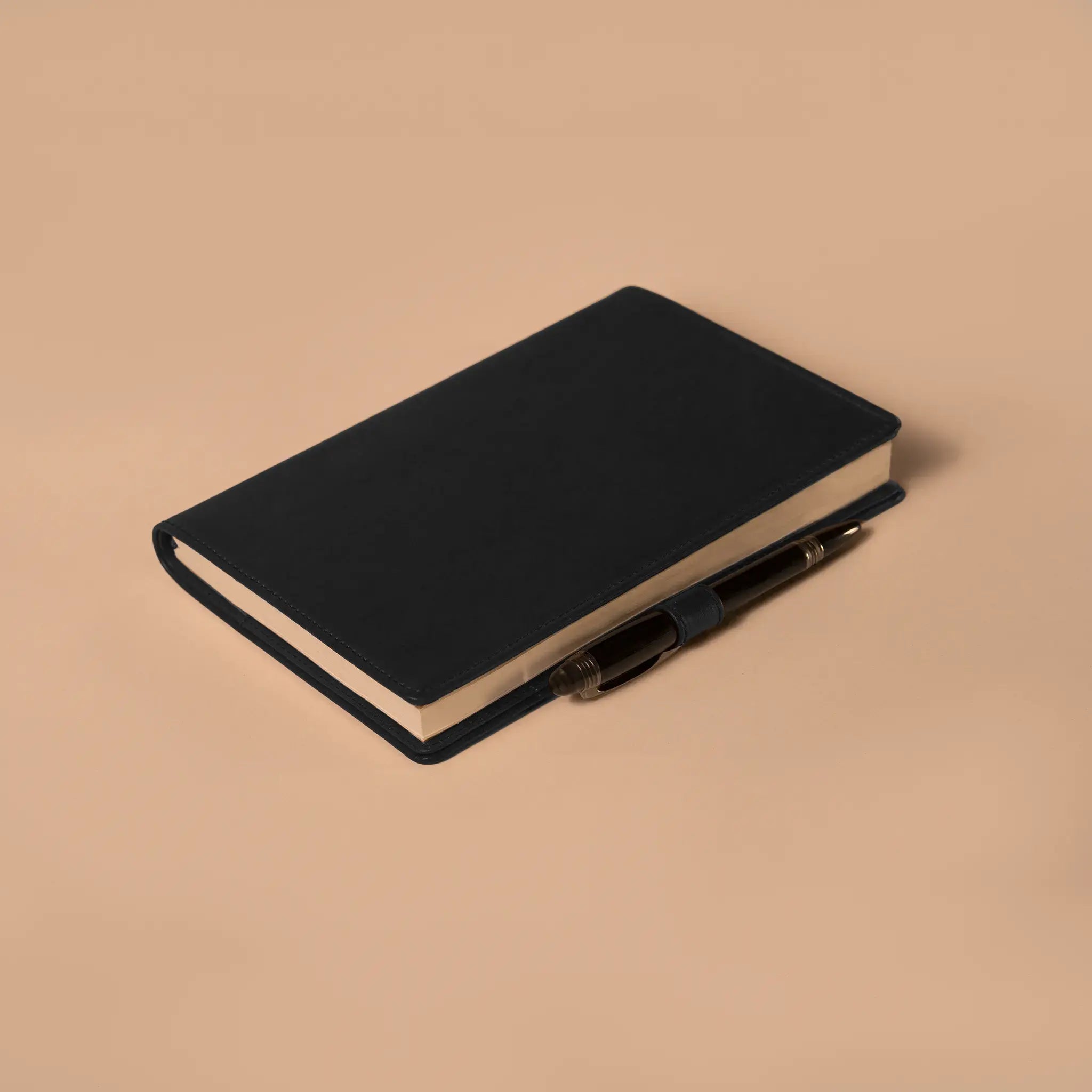 Lunburg Memoir Notebook Cover with Pen Loop in Burnt Timber, close-up detail of the leather pen loop holding a pen along the spine, showing the folded edge construction and page block, in vegetable-tanned Perpetual Leather (from Tempesti).