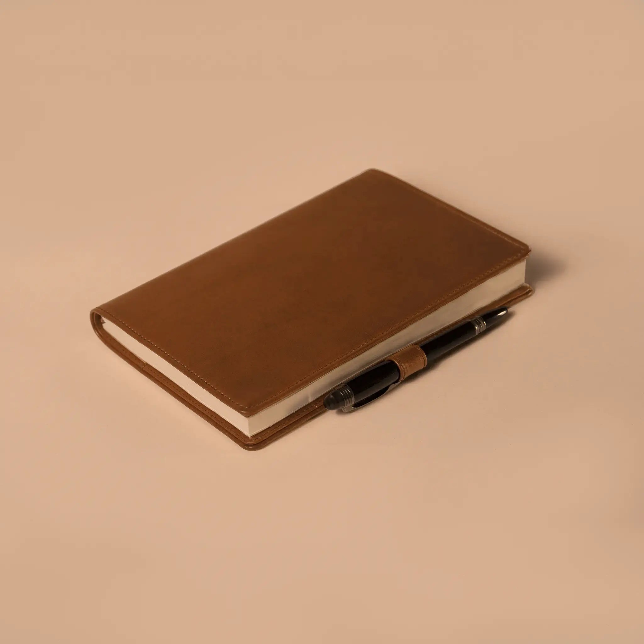 Lunburg Memoir Notebook Cover with Pen Loop in Heritage Amber, close-up detail of the leather pen loop holding a pen along the spine, showing the folded edge construction and page block, in vegetable-tanned Perpetual Leather (from Tempesti).