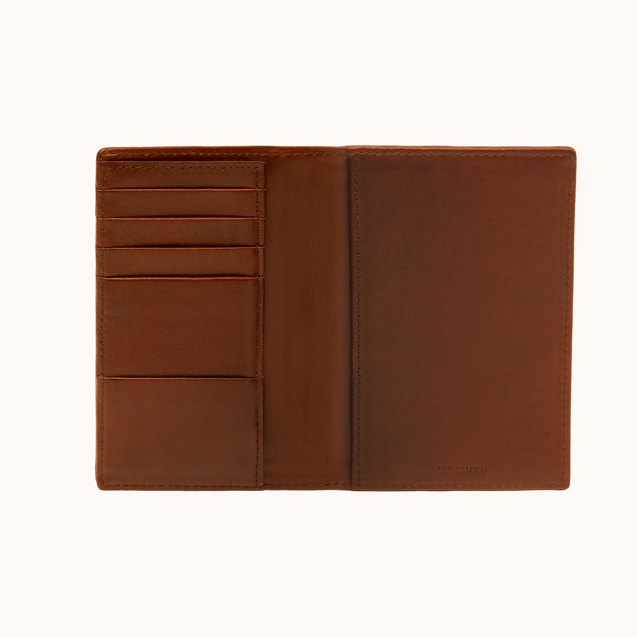 Lunburg Signet Passport Folio in Deep Mahogany, fully open interior view showing card slots and an open pocket on the left panel, a full-height passport sleeve on the right panel, and the heat-embossed Lunburg mark on the lower right, in vegetable-tanned Perpetual Leather (from Tempesti) with folded edge construction throughout.