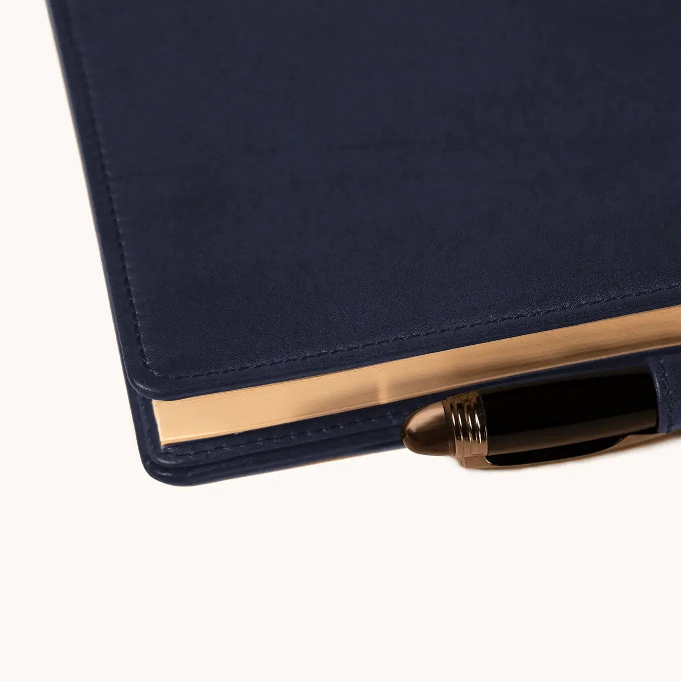 Lunburg Memoir Pocket Notebook Cover with Pen Loop in Nocturnal Sapphire, close-up detail of the leather pen loop holding a pen along the spine, showing the folded edge construction and page block, in vegetable-tanned Perpetual Leather (from Tempesti).