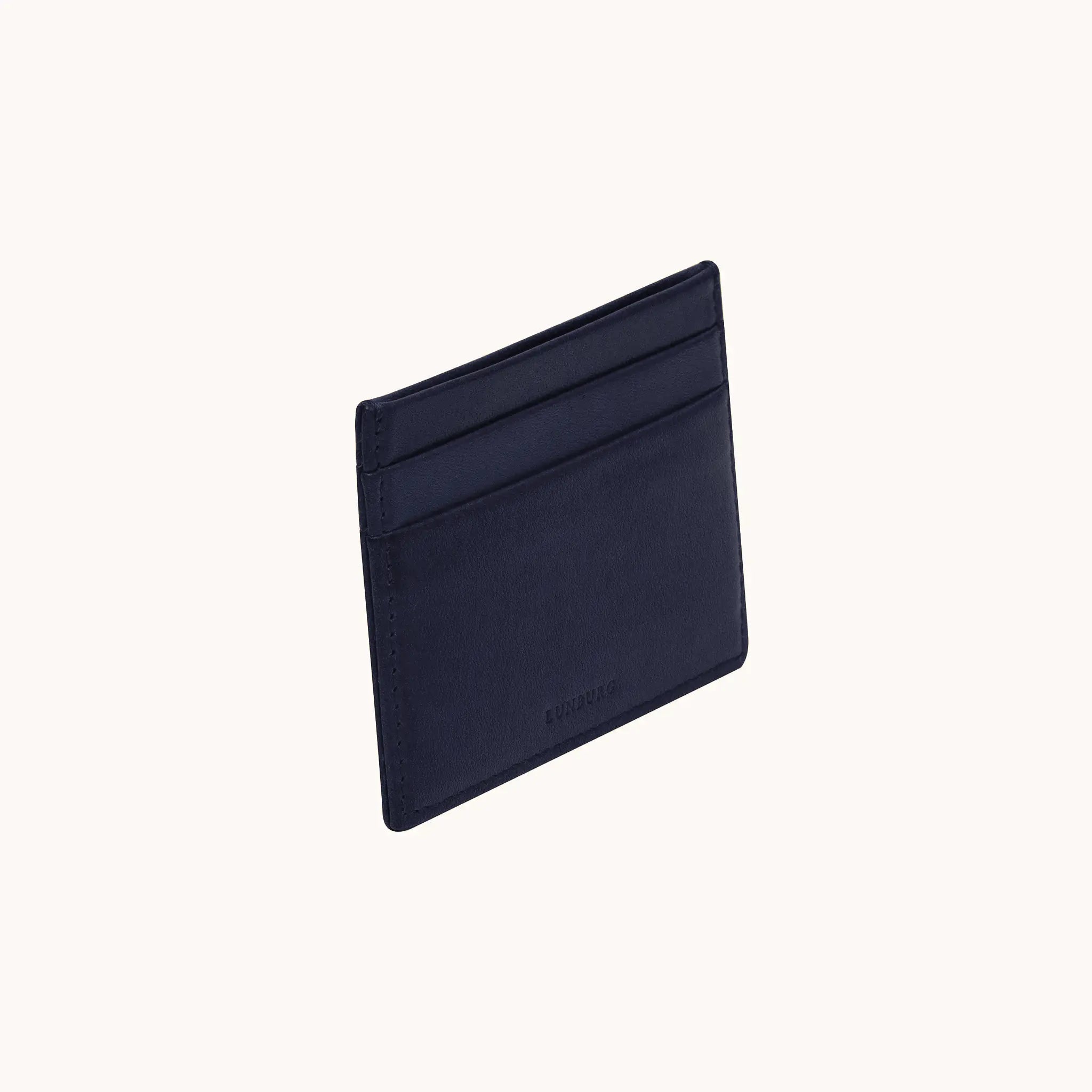 Lunburg Signet Card Holder in Nocturnal Sapphire, three-quarter view showing the card slots and heat-embossed Lunburg mark, in vegetable-tanned Perpetual Leather (from Tempesti) with folded edge construction.