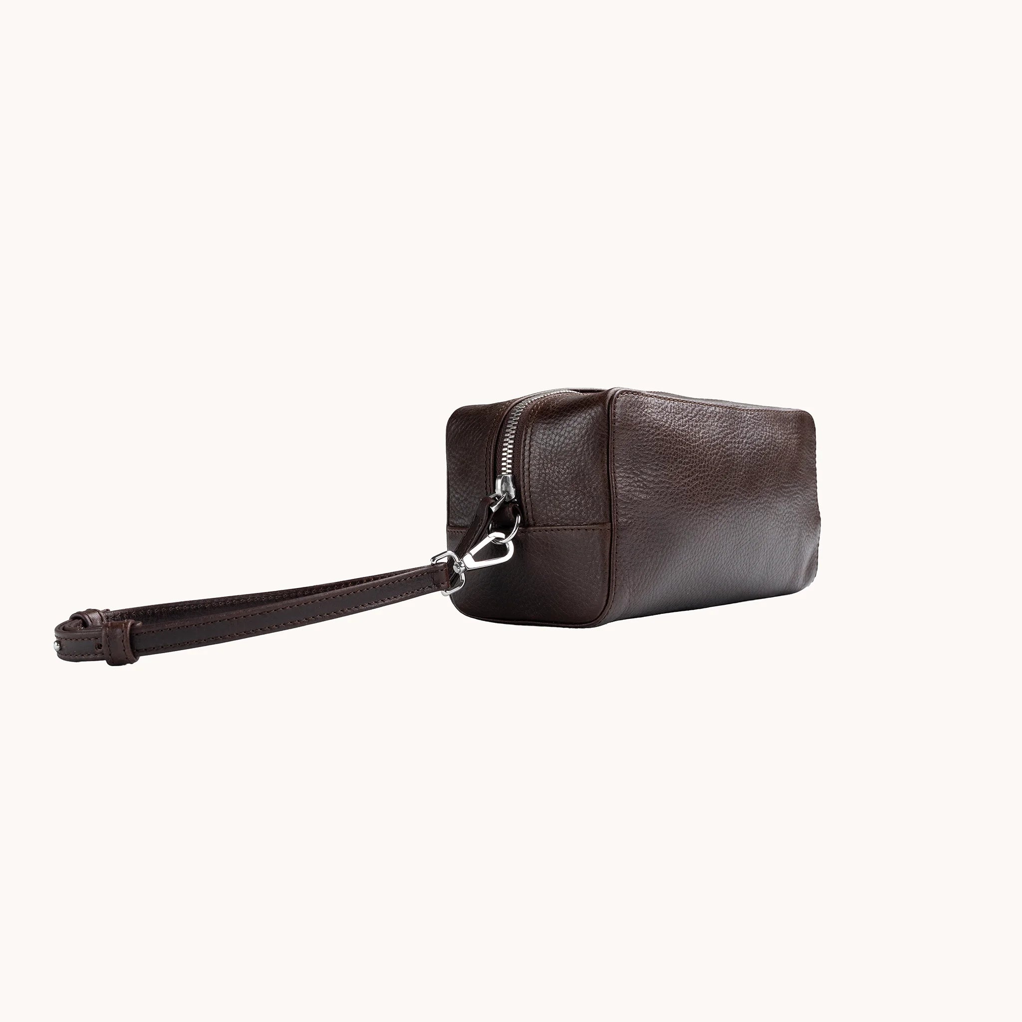 Lunburg Chamberlain Toiletry Bag in tumbled Deep Mahogany leather, three-quarter view showing depth and zip line.