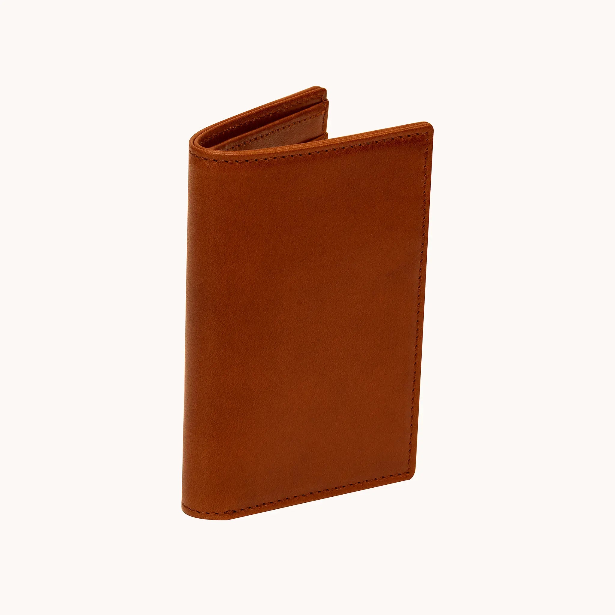 Lunburg Vertical Bifold Wallet in Heritage Amber at a three-quarter angle, slightly open, showing the slim profile, folded edge construction, and edge stitching in vegetable-tanned Perpetual Leather.