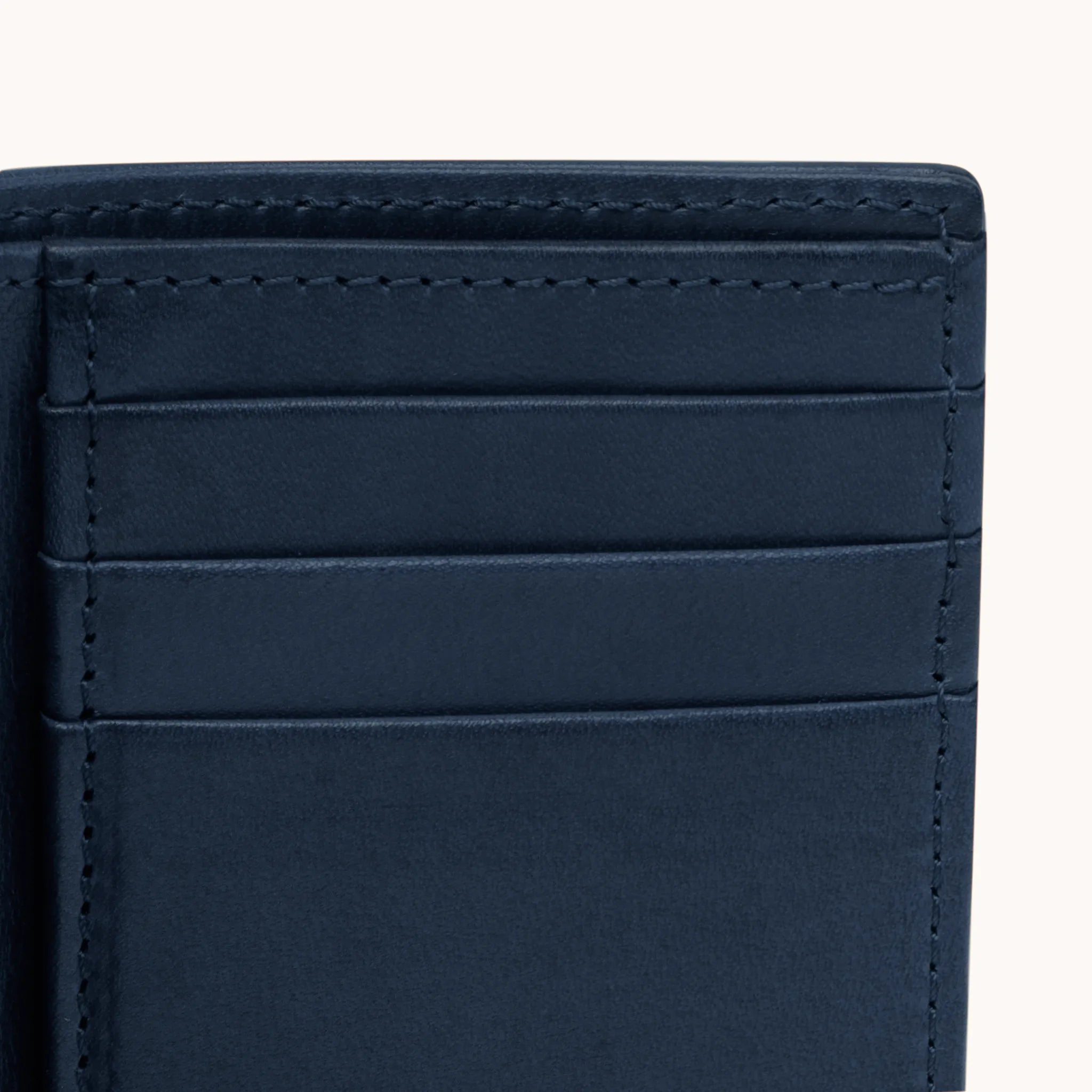 Lunburg Signet Vertical Bifold in Nocturnal Sapphire, close-up detail of the interior card slot layering showing the folded edge construction of Rempliage on each pocket edge, in vegetable-tanned Perpetual Leather (from Tempesti).